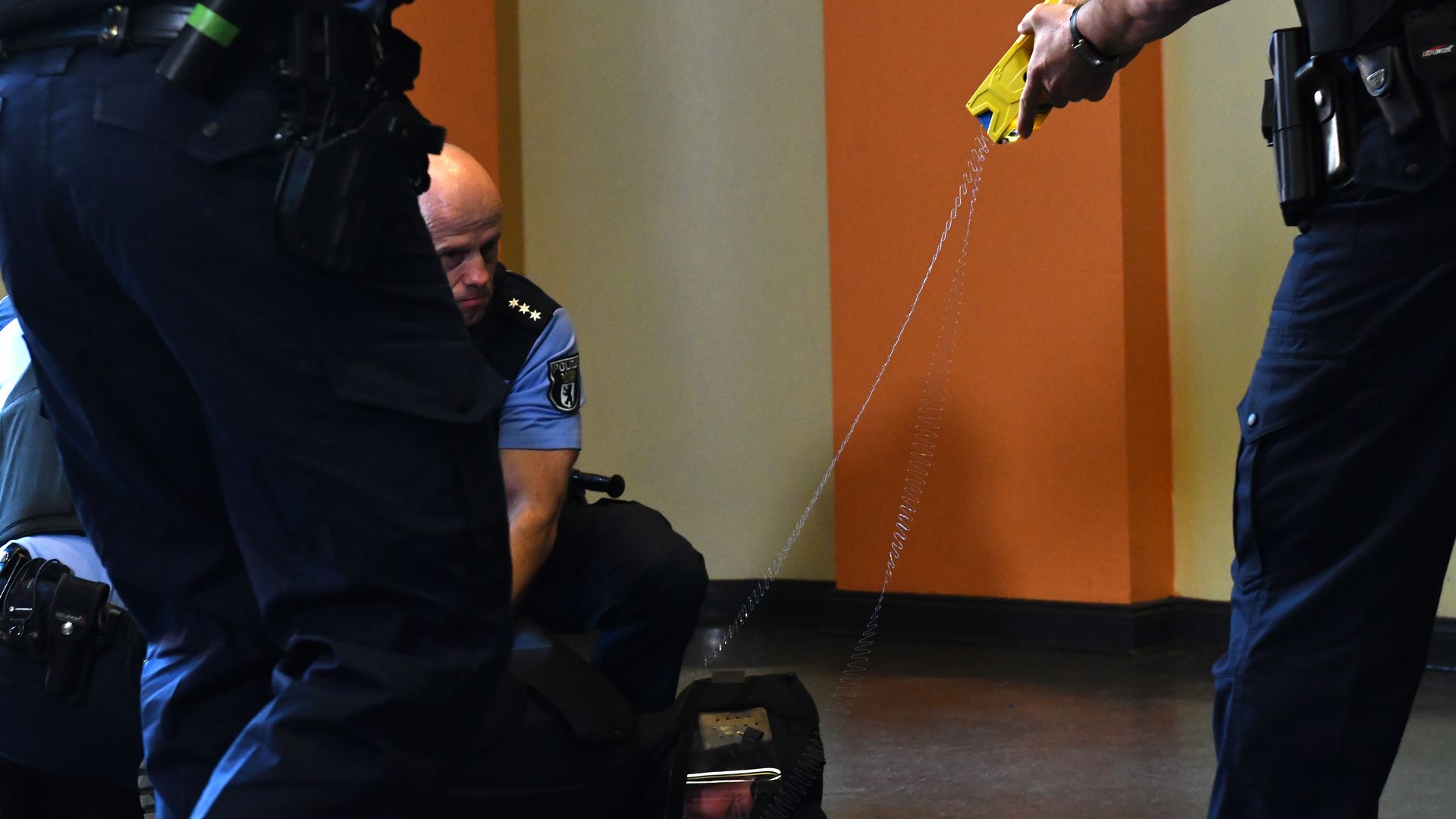 A police officer demonstrates how to use a Taser. 