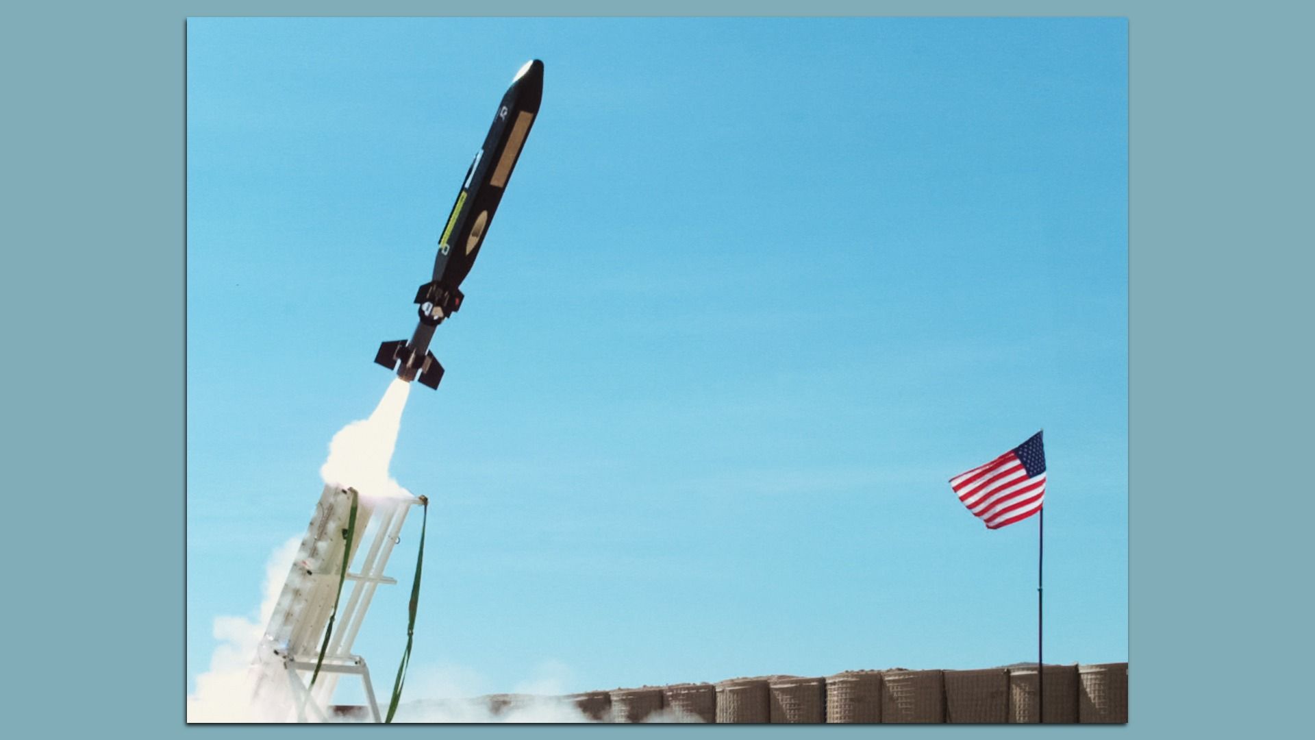 A missile flies out of its launcher. Reinforcement walls and an American flag are seen in the background.