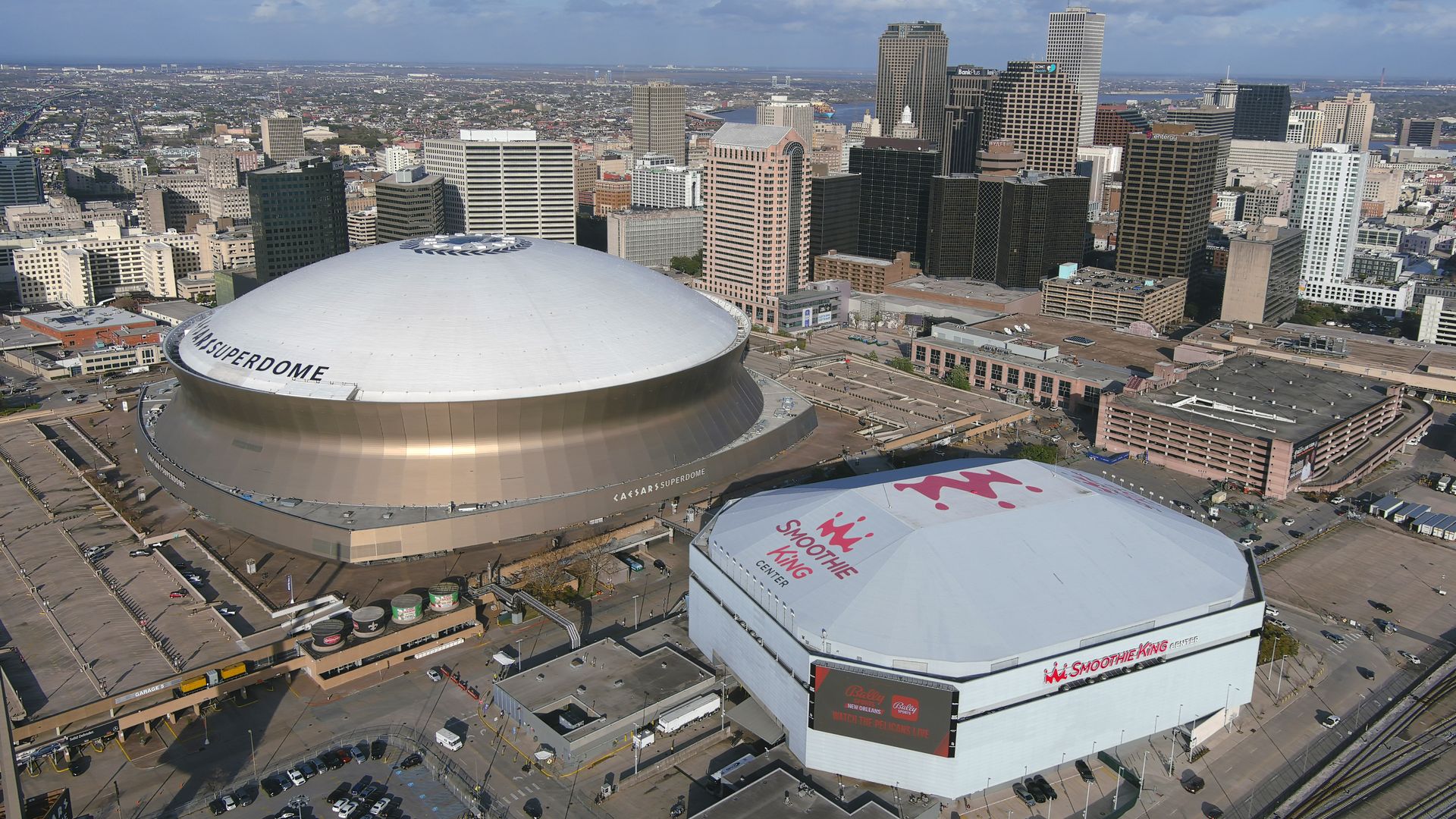Image shows an aerial view of the Superdome and Smoothie King Center.
