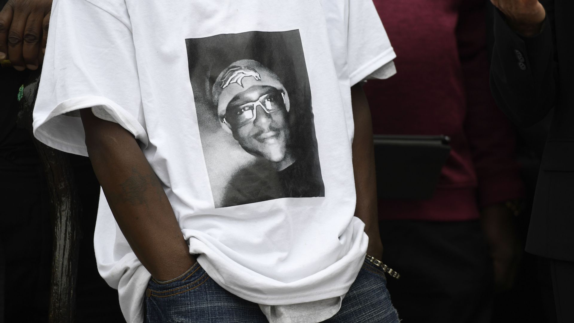A man wears a t-shirt with Elijah McClain's face on it during a protest