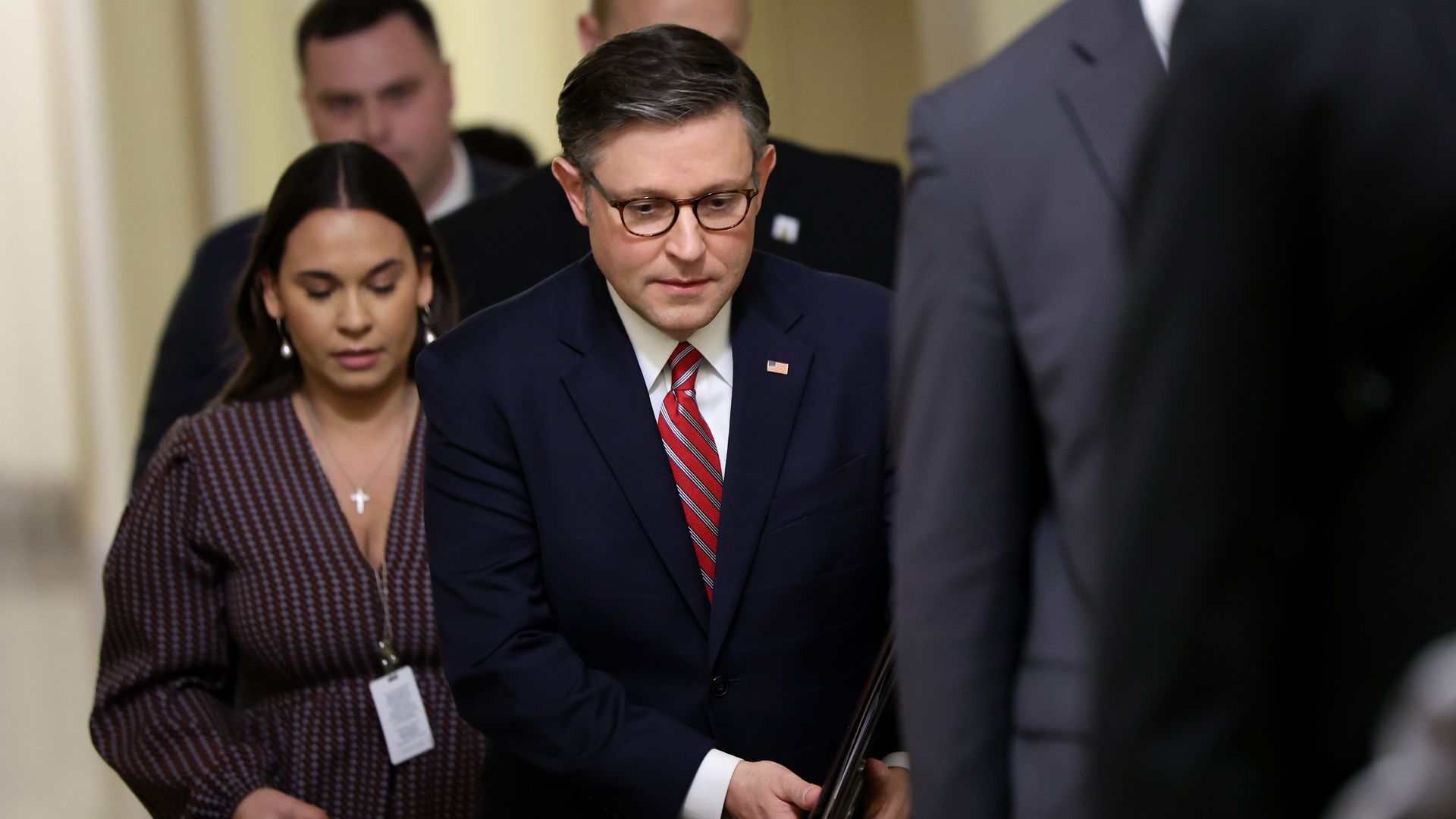 House Speaker Mike Johnson, wearing a dark blue suit, white shirt and red tie.