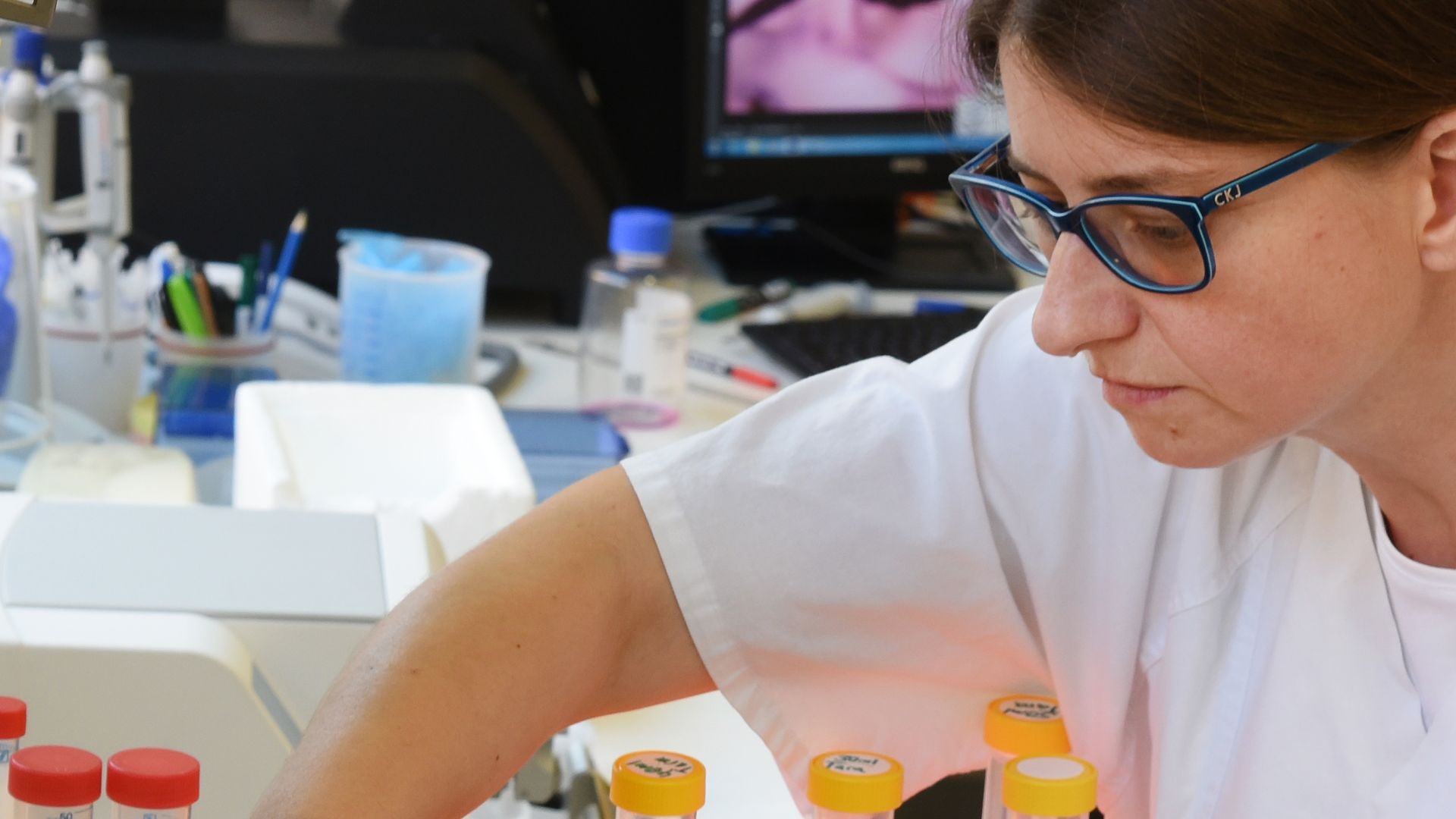 A woman puts a test tube down. 