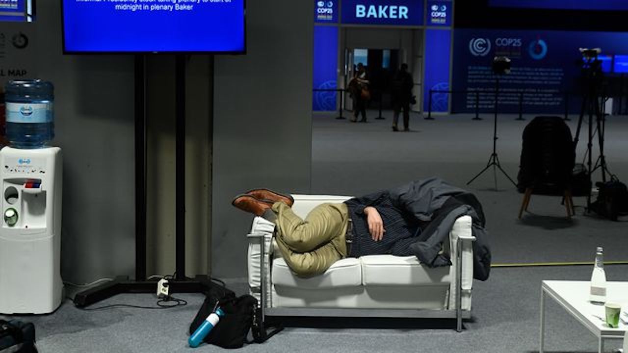 Photo of a man sleeping on a sofa at the United Nations climate conference in Madrid.