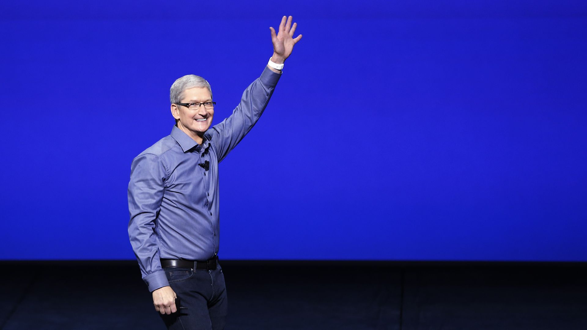 Tim Cook in front of a blue backdrop