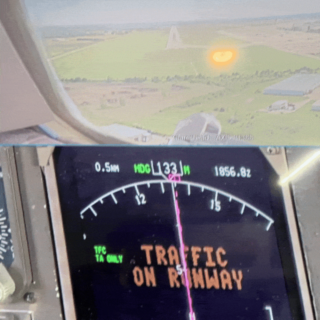Video shows a two screens, one screen saying "TRAFFIC ON RUNWAY" and the other showing the approaching runway from a different camera.