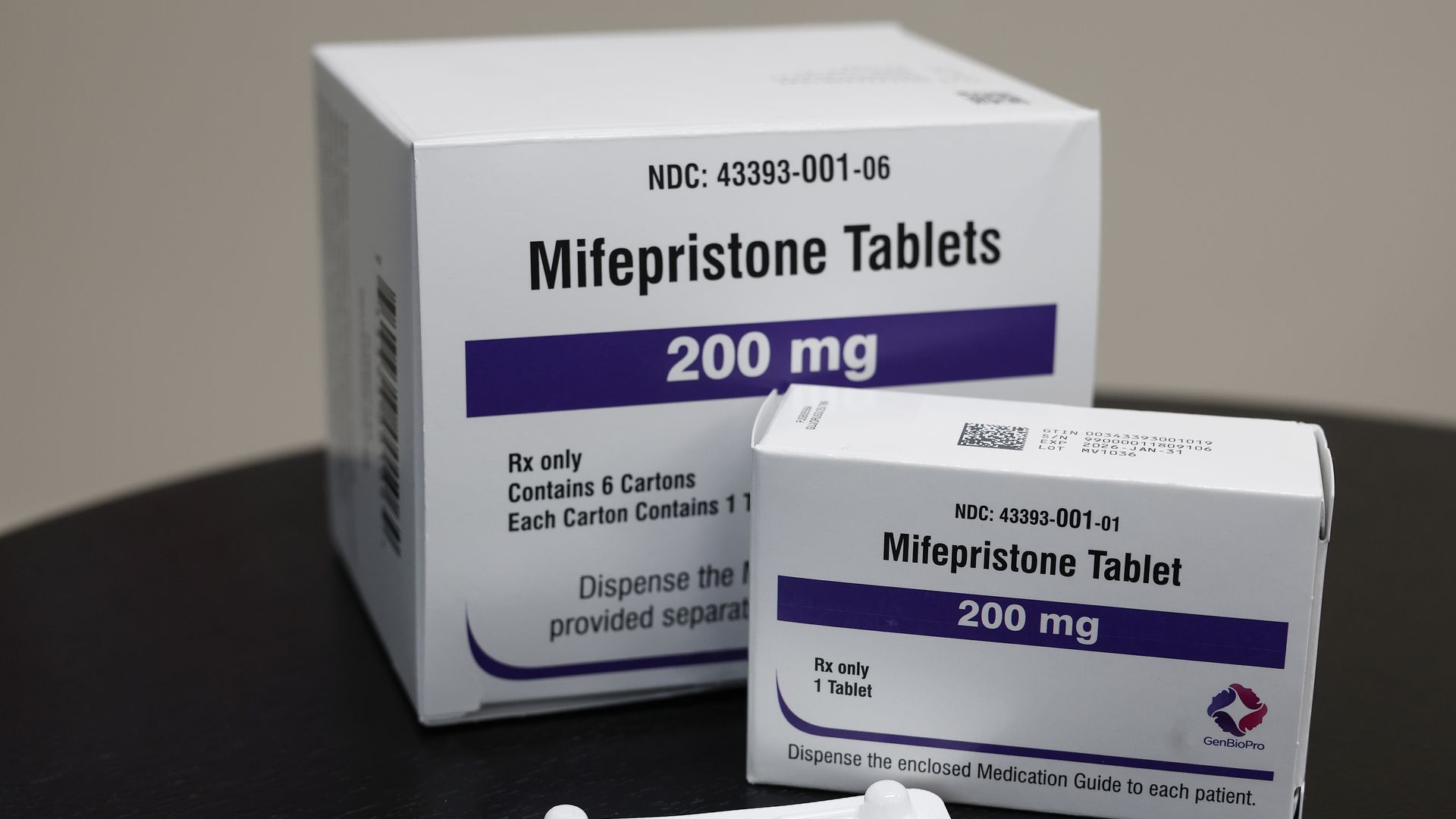 This photo illustration displays two white and purple boxes of Mifepristone tablets.