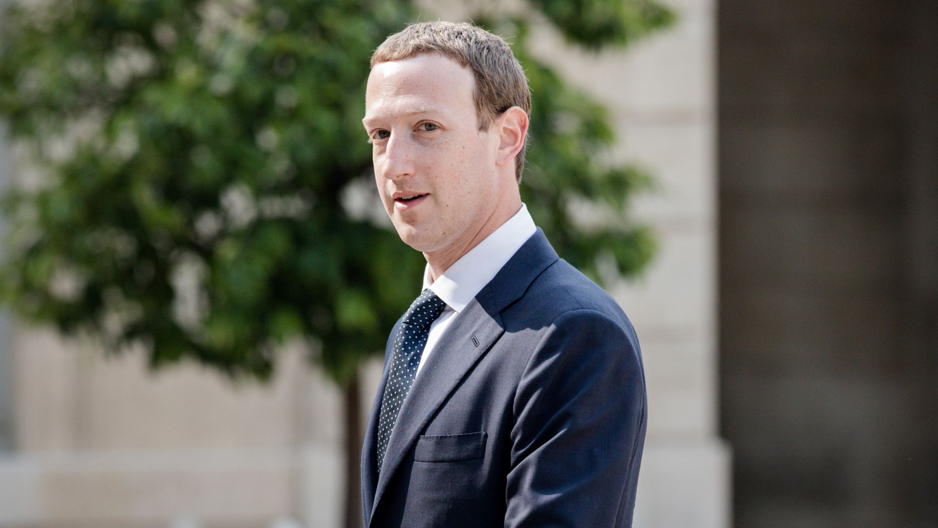 Mark Zuckerberg, photographed outside and wearing a suit