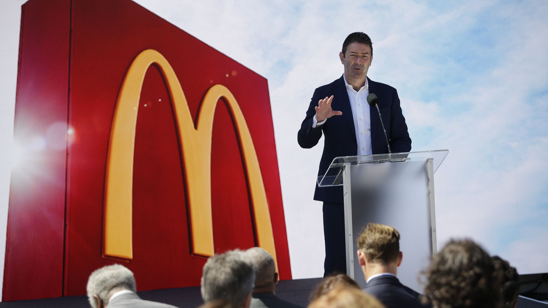 Photo of Steve Easterbrook speaking from a podium with a giant McDonald's logo behind him