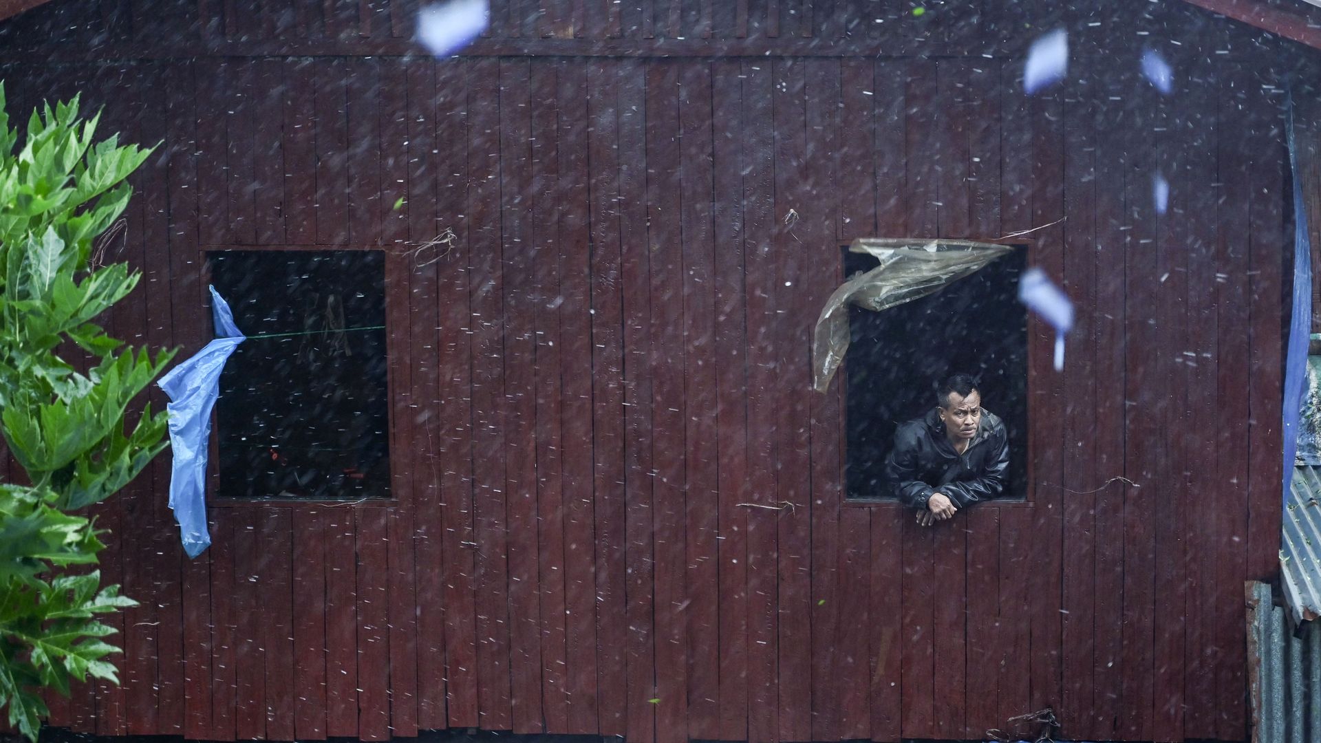 A man looks out from a window in Myanmar's Rakhine State during Tropical Cyclone Mocha on May 14.