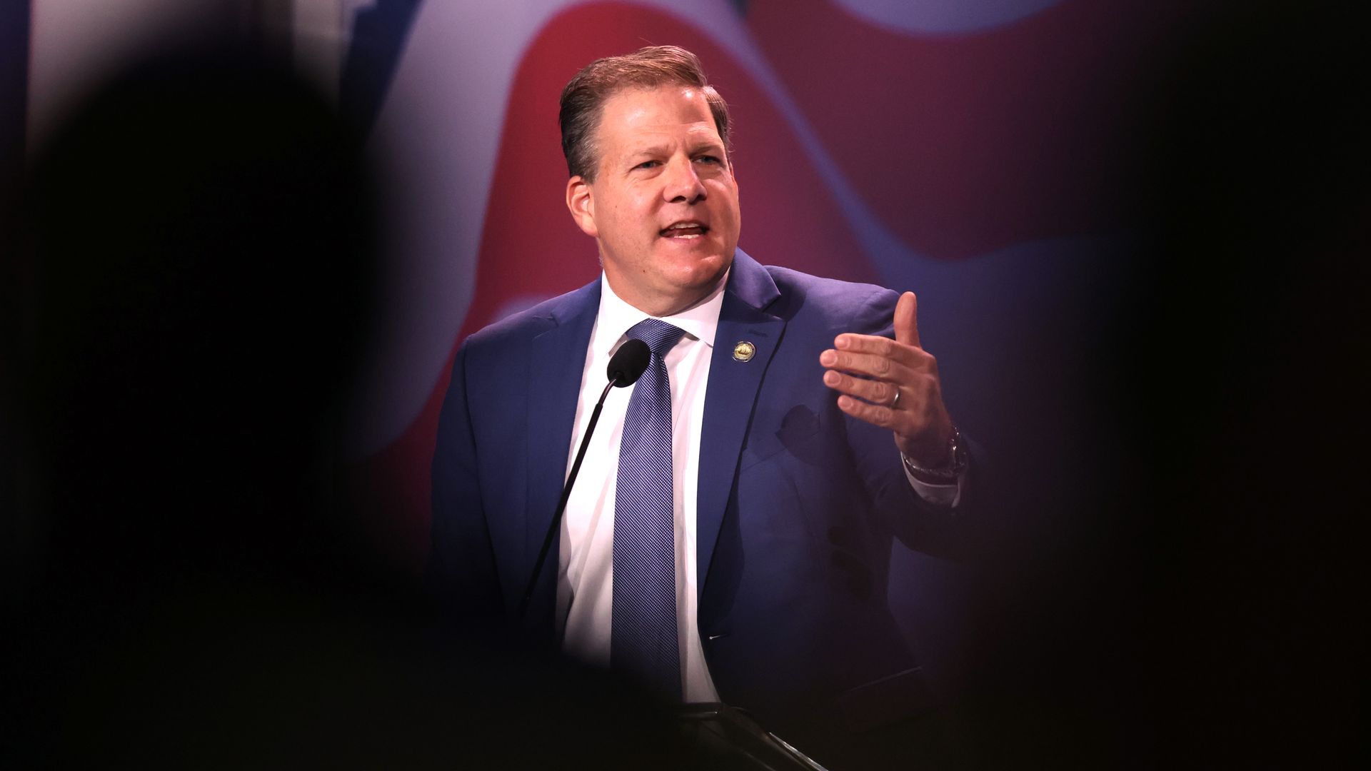 Gov. Chris Sununu speaking wearing a blue suit