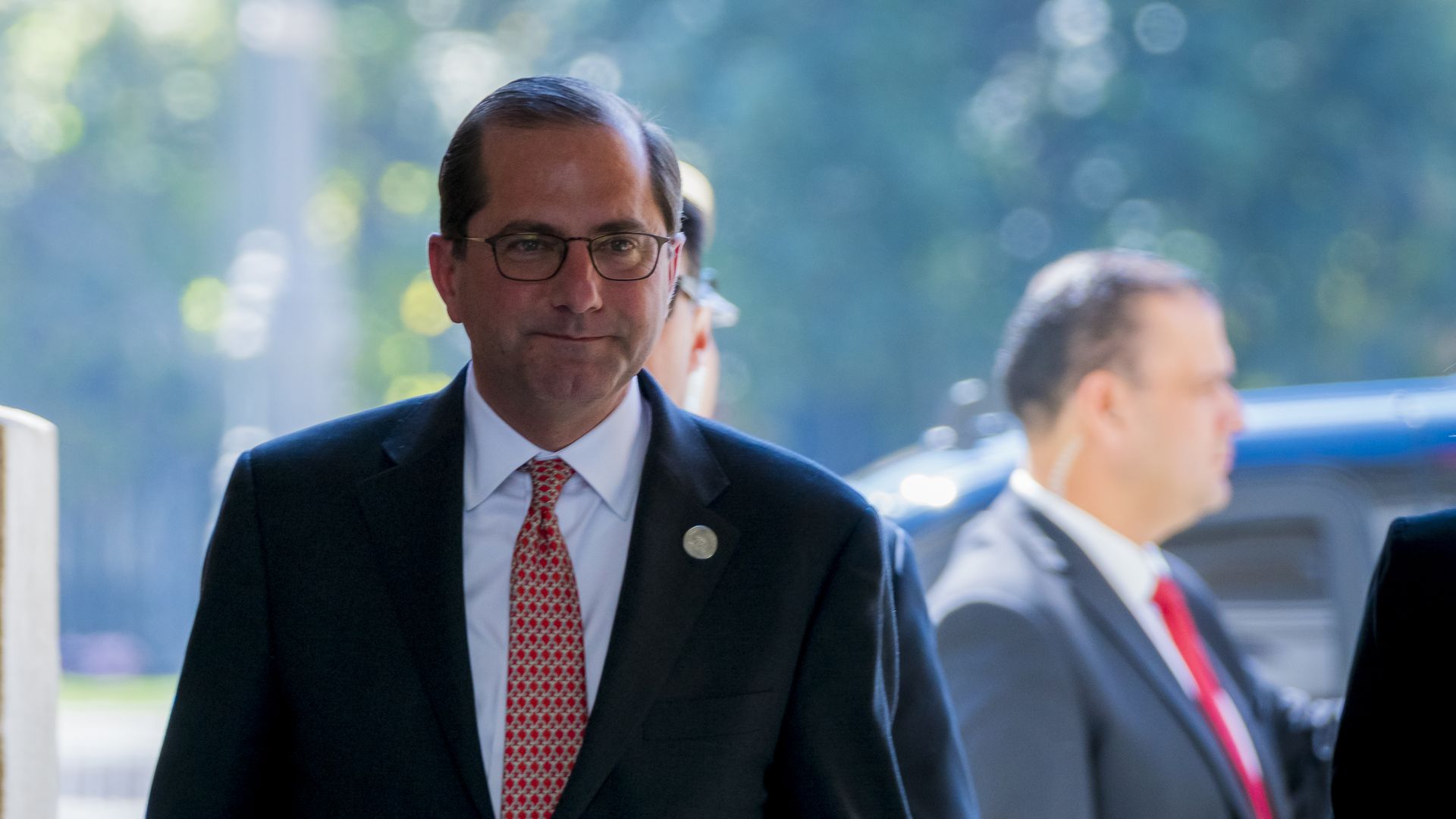 HHS Secretary Alex Azar, walking, with an expression that appears confident.