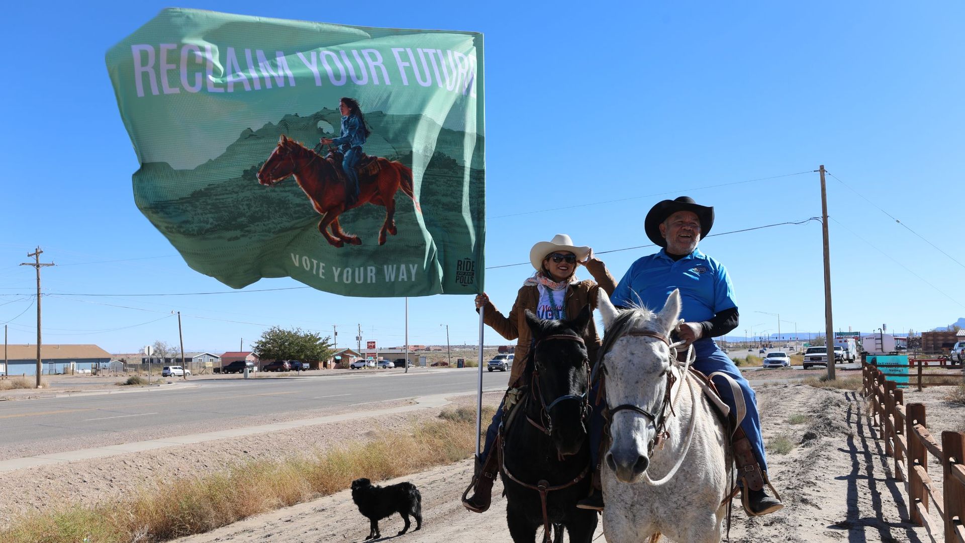 A woman and man on horseback carrying a flag that says, "Reclaim your Future."