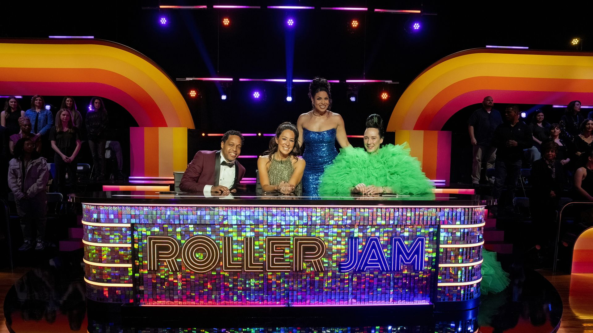 Photo shows the judges of "Roller Jam" sitting behind a colorful table with a mirror floor.