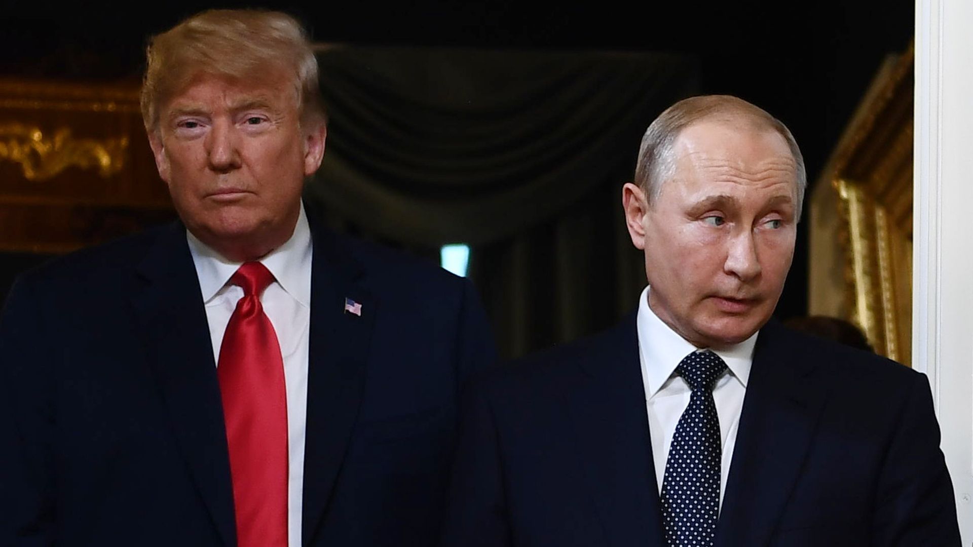 Trump and Putin walk through a doorway side by side