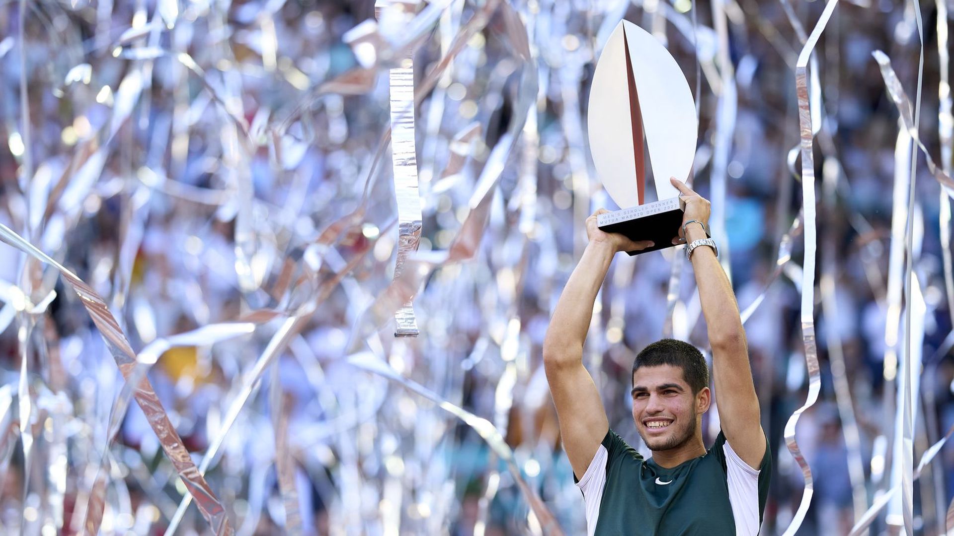 Carlos Alcaraz holds a trophy after winning the Madrid Open.