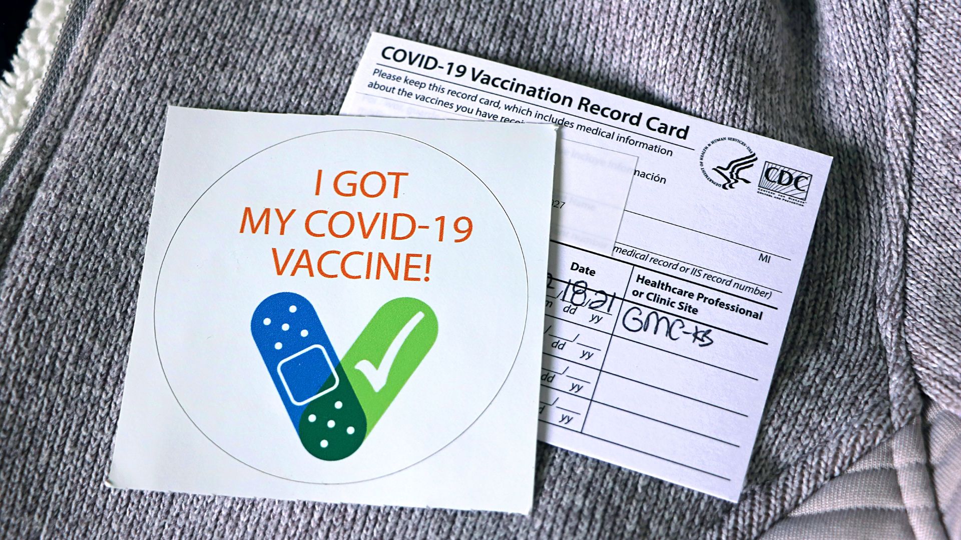 Image of a COVID-19 vaccination record card and a sticker that says, "I got my covid-19 vaccine!"