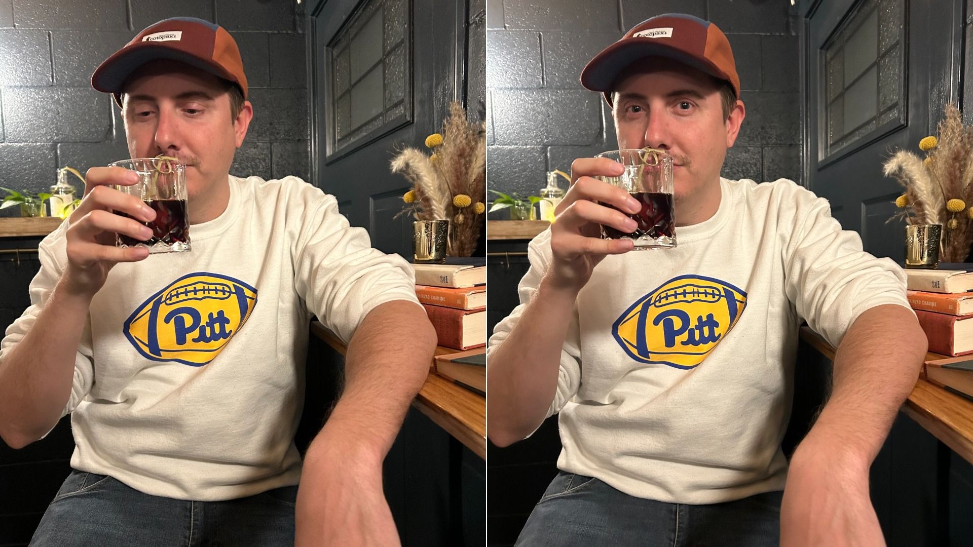 Two side-by-side photos of a man in a Pitt sweatshirt and orange cap, sipping a dark drink from a short glass indoors, with books and dried plants on a wooden table.