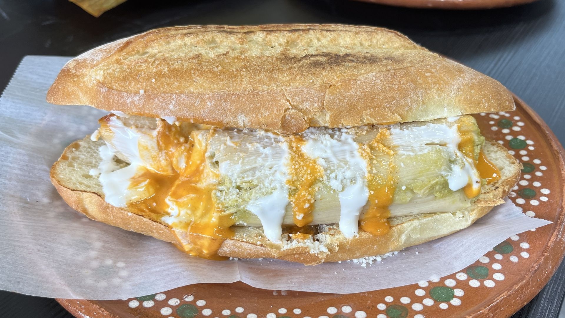A tamale with sauce on a baguette.