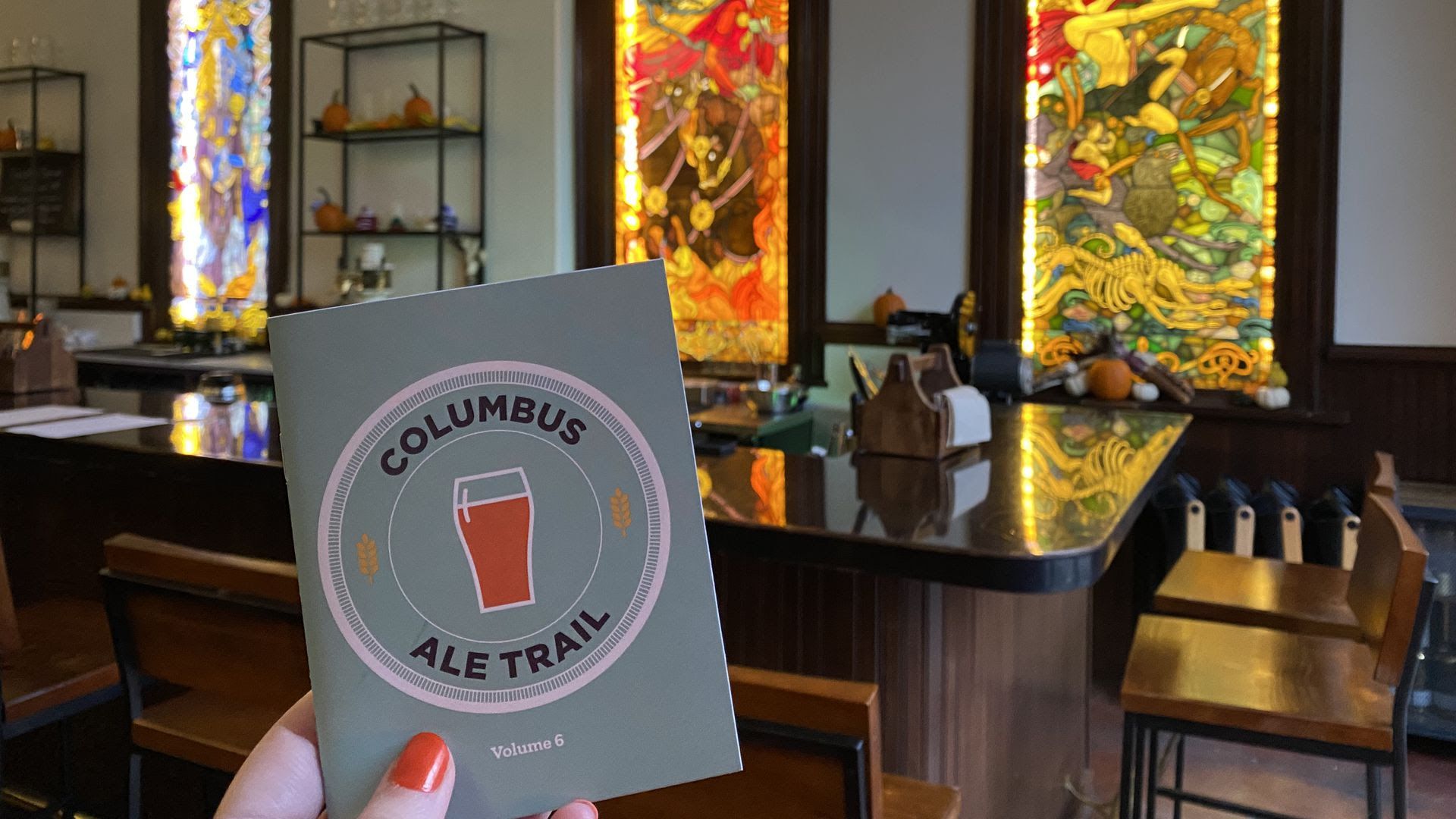 The stained-glass windows behind the bar at Gemüt Biergarten are the perfect backdrop for the Columbus Ale Trail book