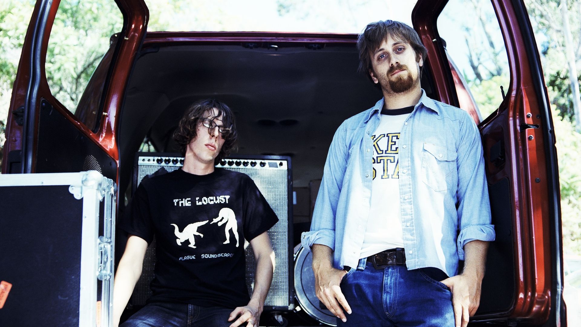 Patrick Carney and Dan Auberbach stand at the back of their open touring van circa 2003. 