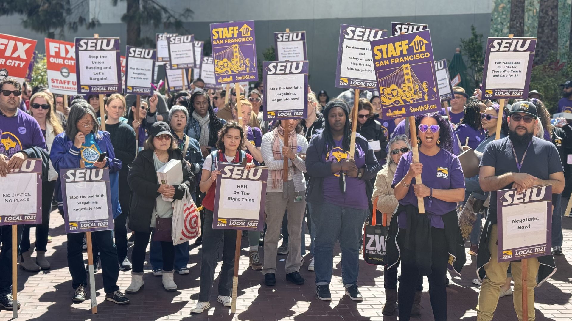 workers hold up signs