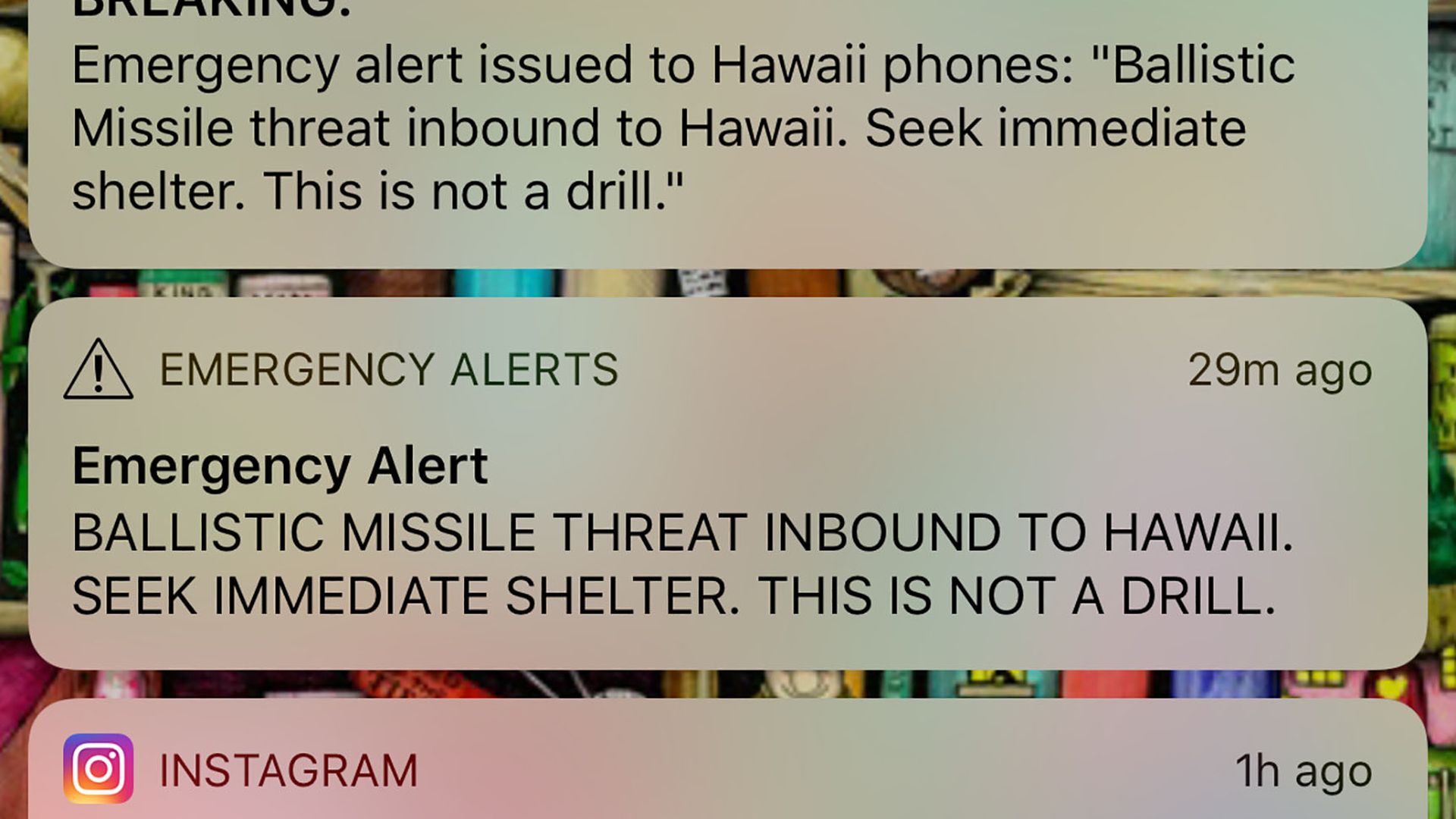 A phone screen shows a false ballistic missile alert in Hawaii