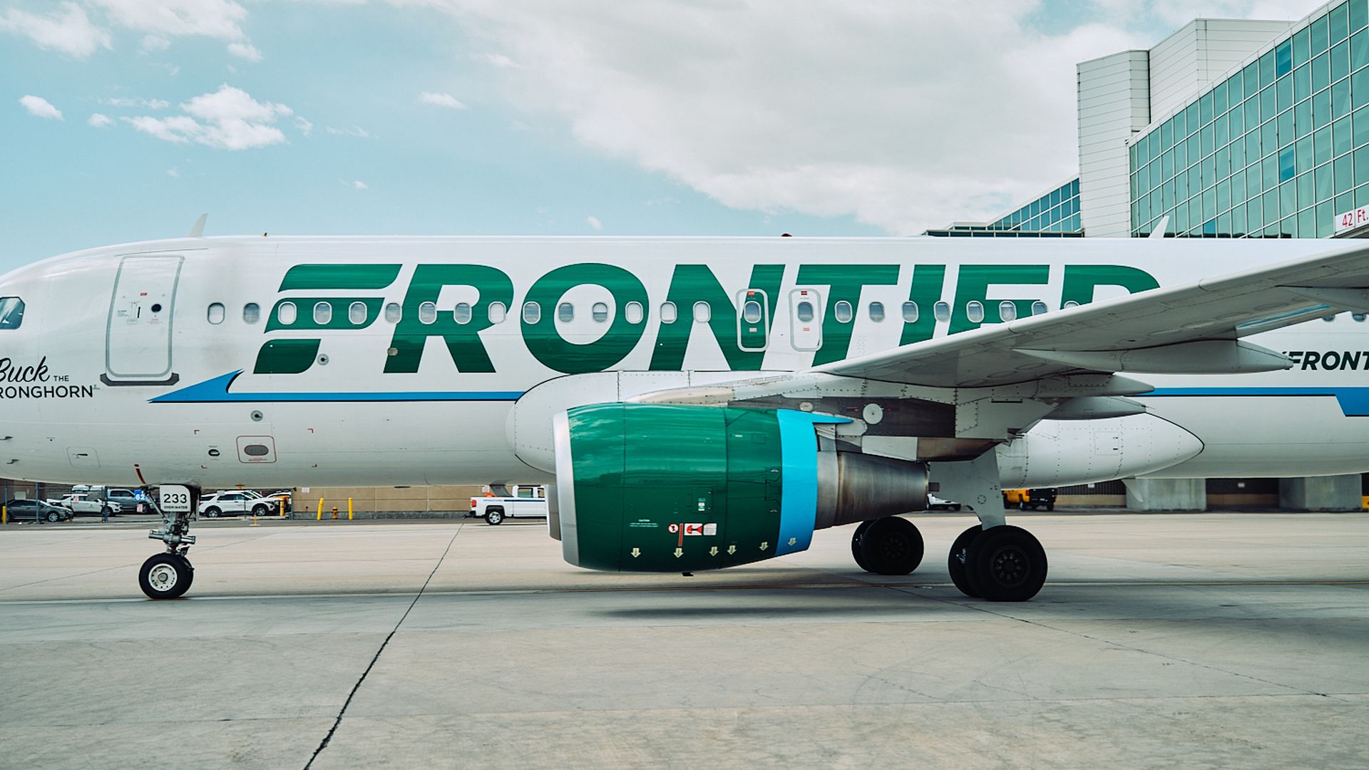 A Frontier airplane in profile on a tarmac.