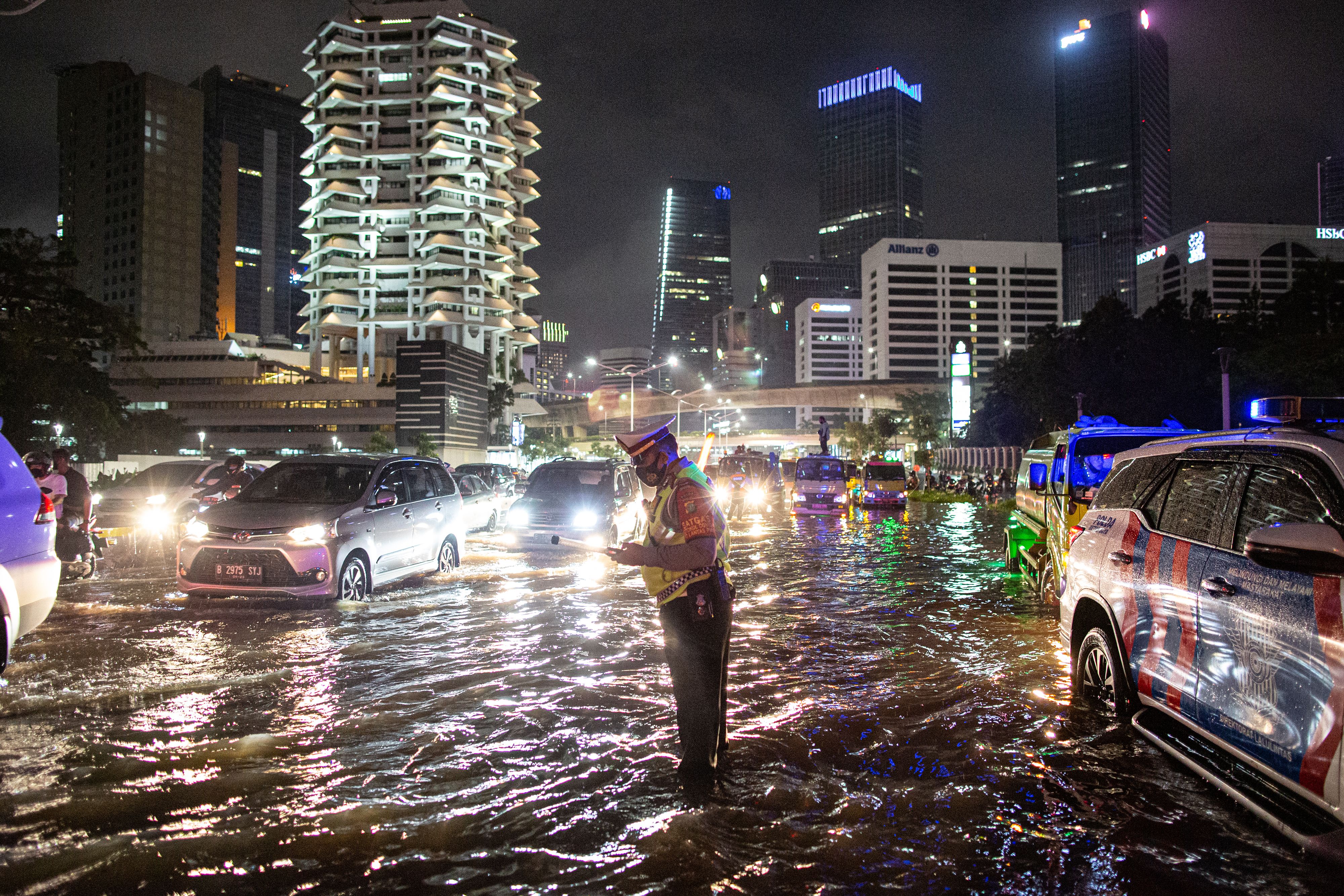 Police officer control traffic jam at a flooded business district in a main road in Jakarta
