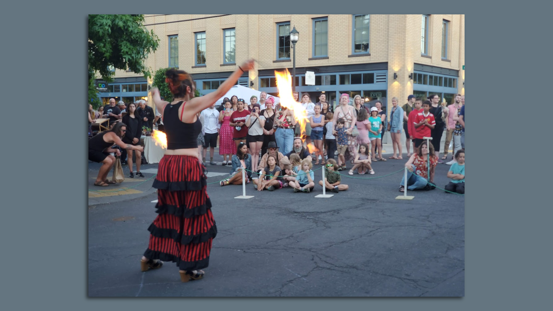 Fire dancer in the street in front of a crowd