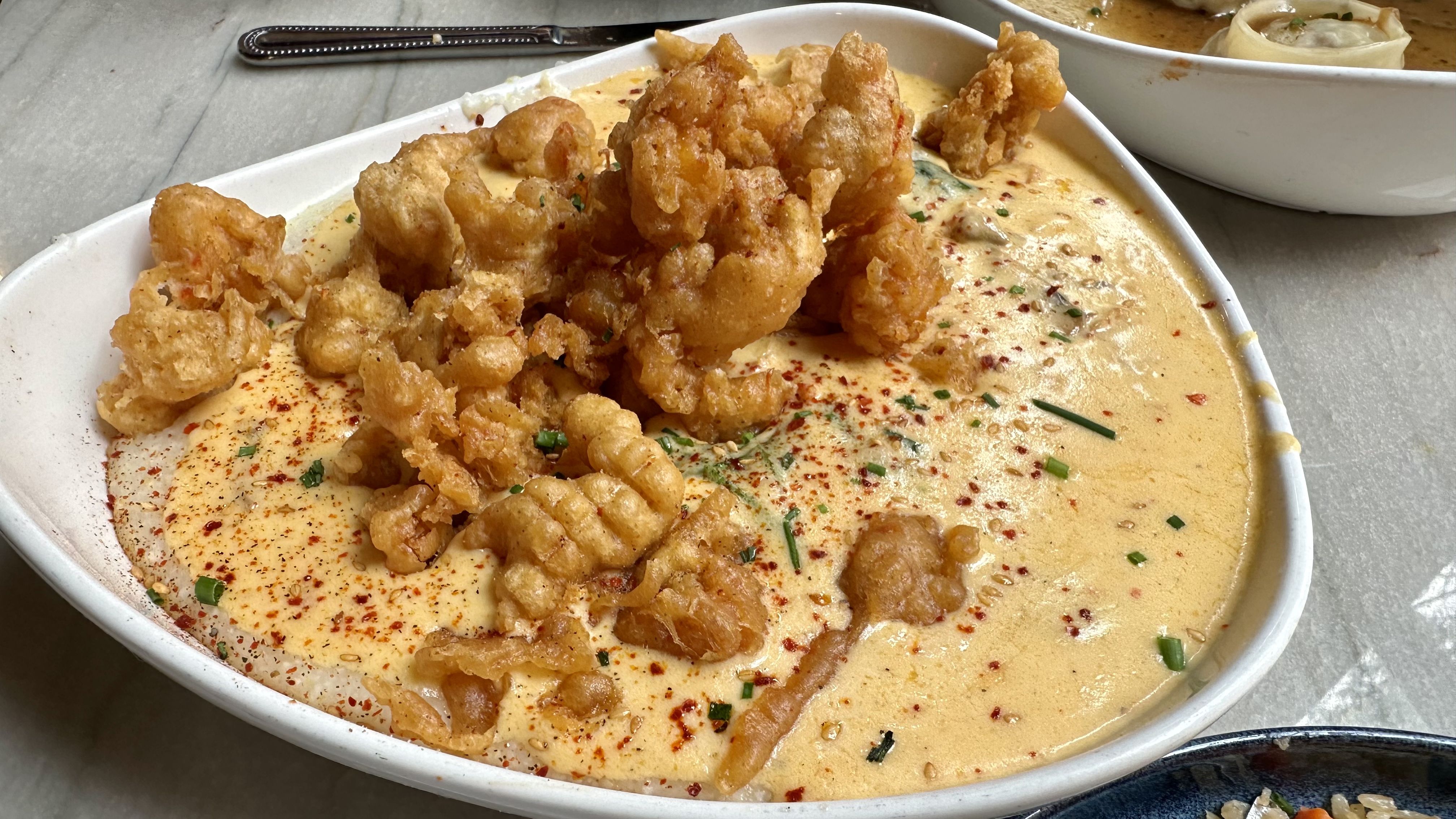 Photo shows tempura crawfish over cheese grits.