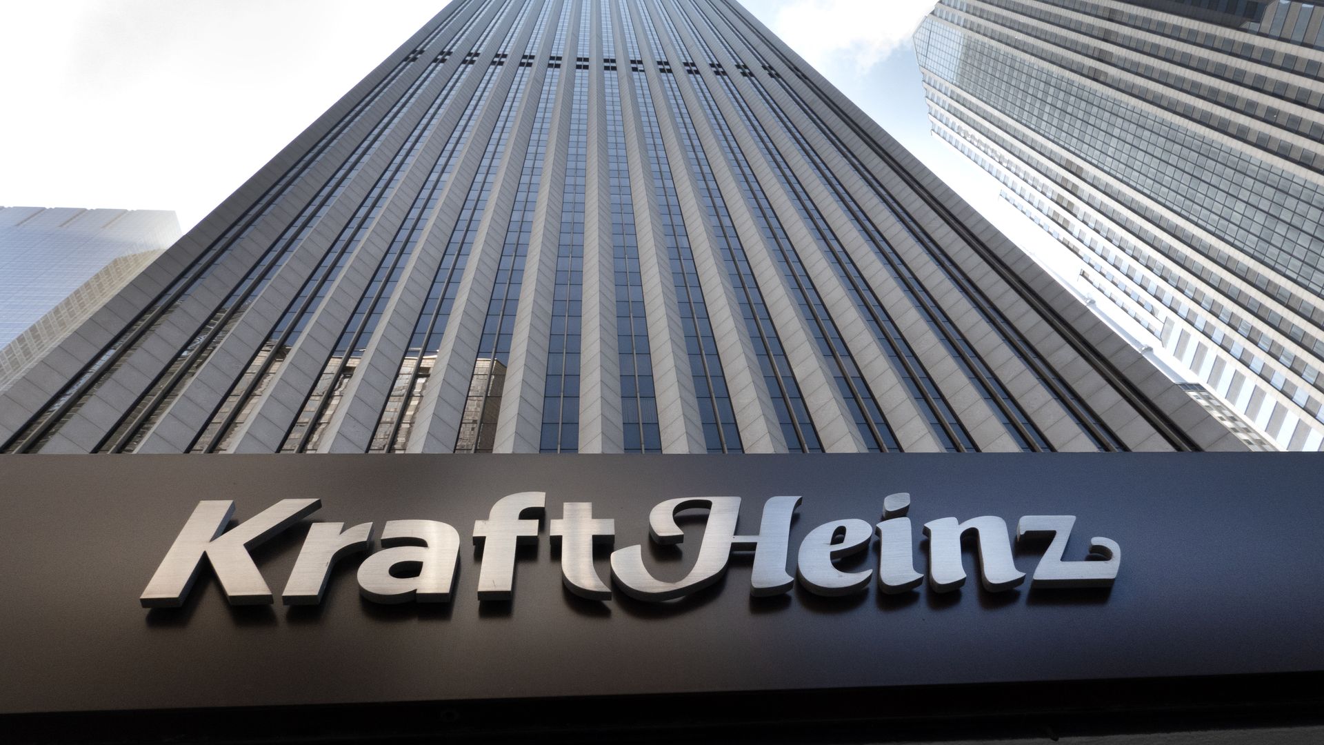 A view looking up at a towering skyscraper with the logo for Kraft Heinz