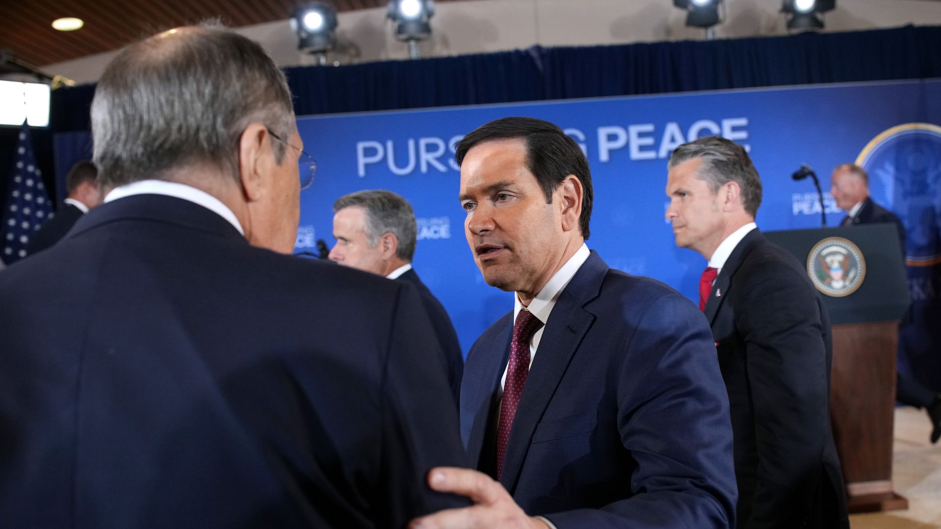 Secretary of State Marco Rubio holds the arm of Russian Minister of Foreign Affairs Sergey Lavrov as he talks to him at the end of a press conference.