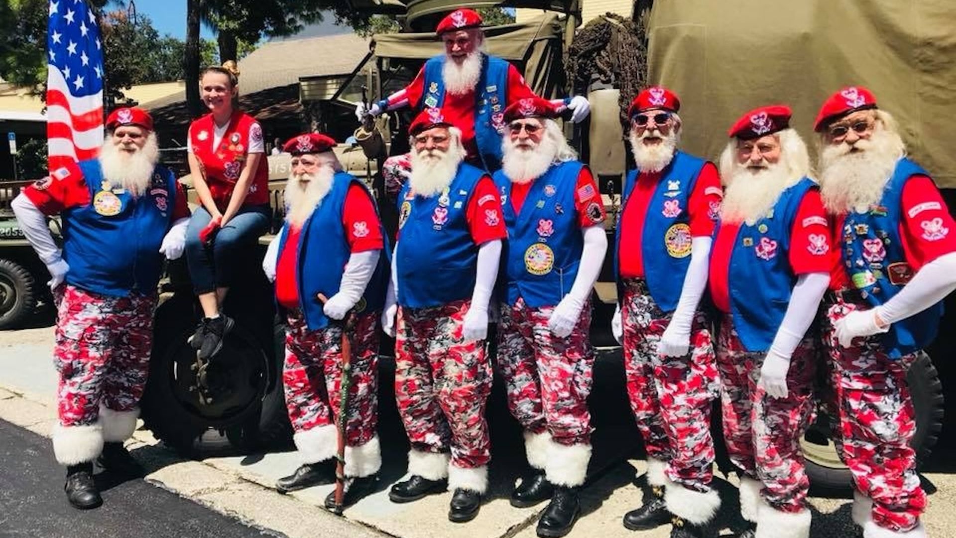 Santa's Drill Team memebrs in red and white camo pants, blue vets, red shirts and white berets