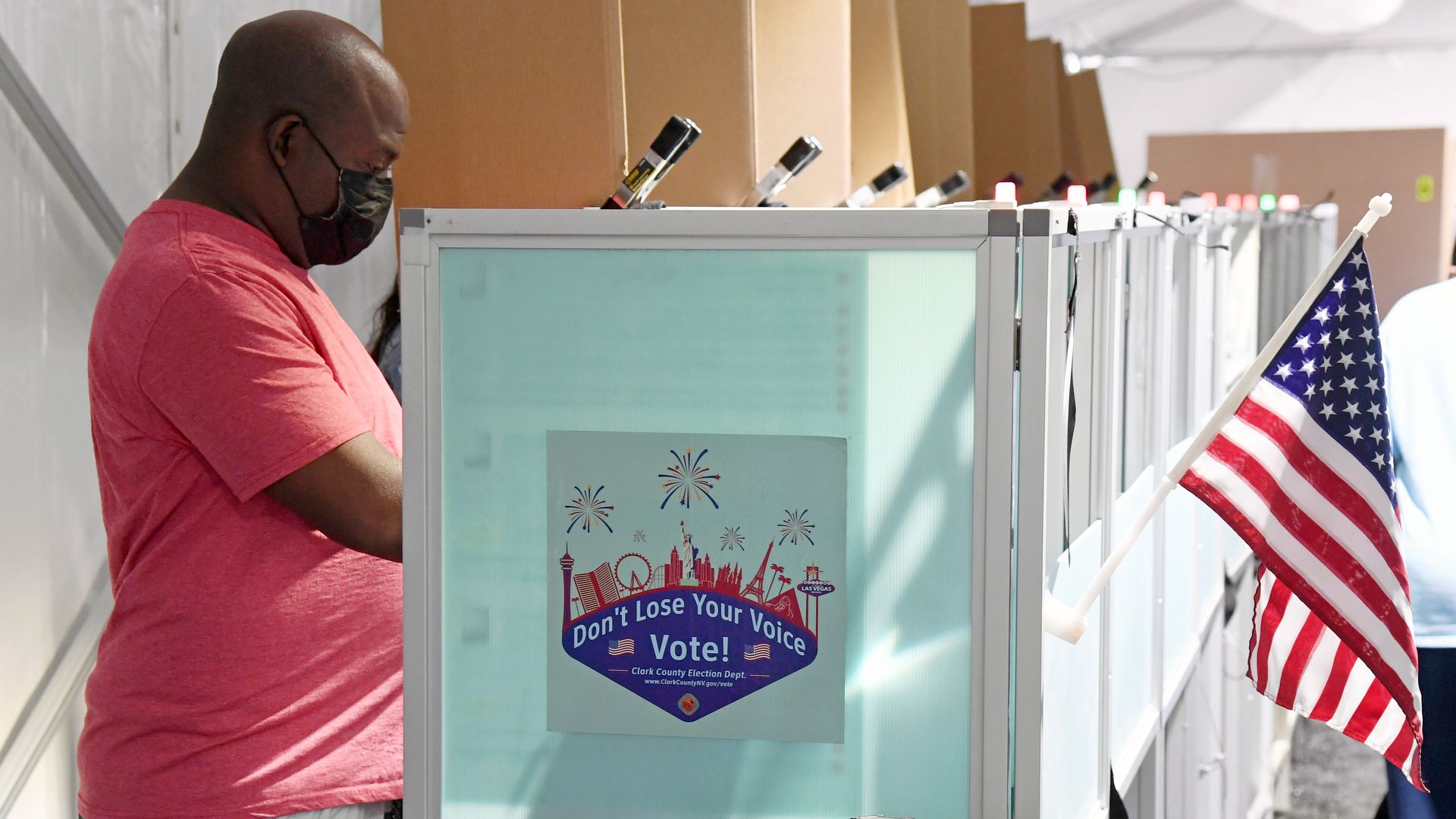 A photo of a man voting at a voting booth in Las Vegas