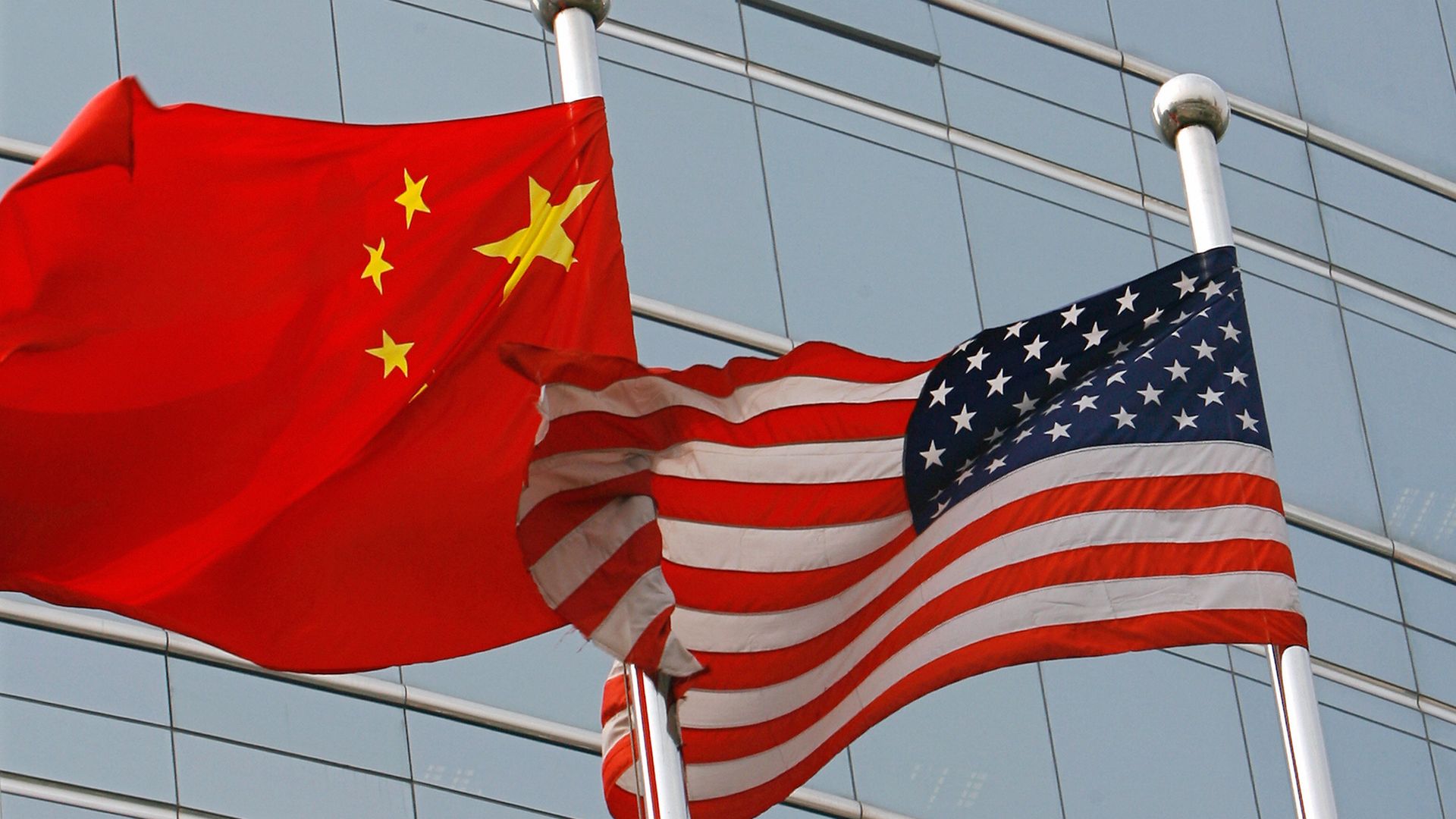 Chinese and American flags waving next to each other