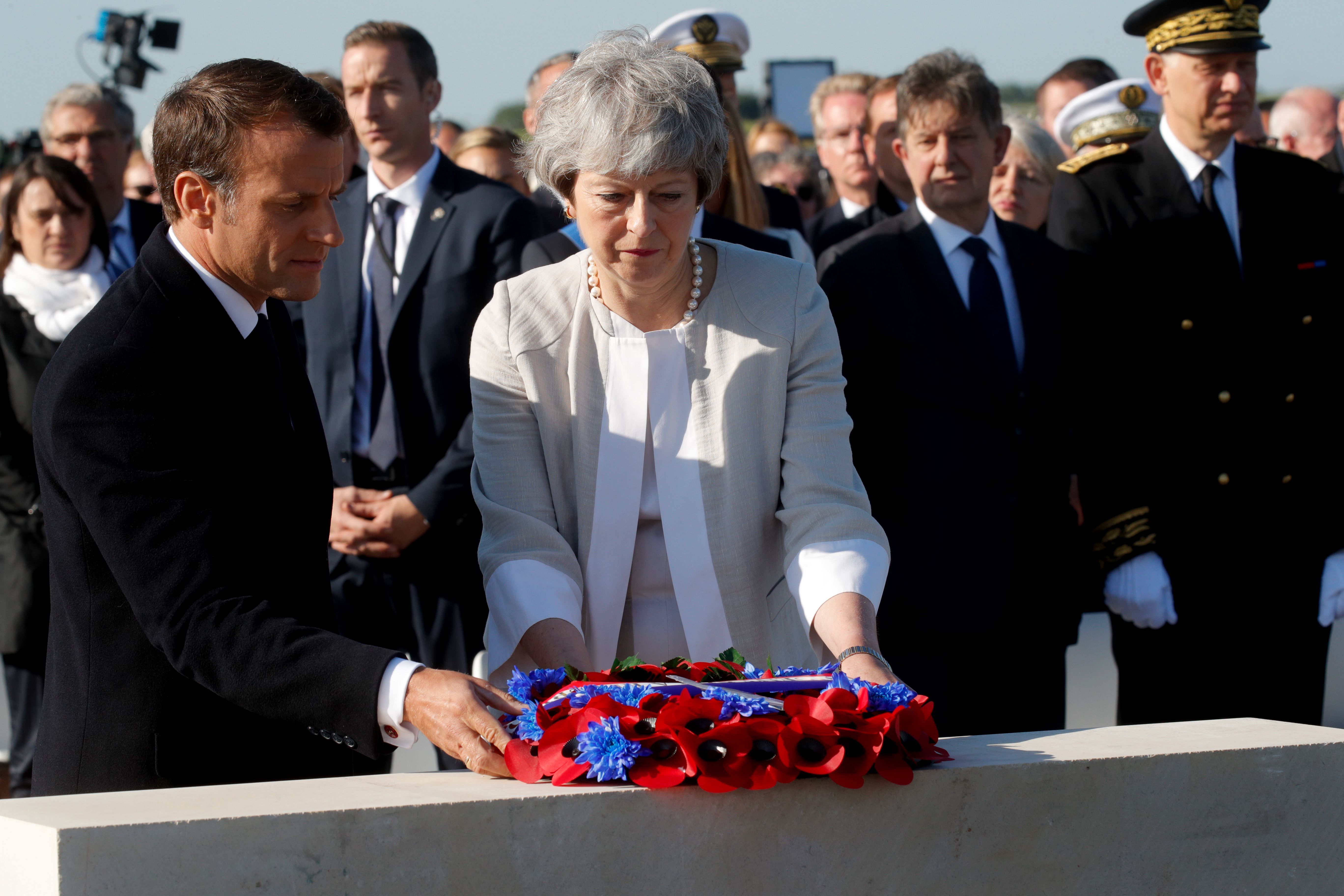 French President Emmanuel Macron and British Prime Minister Theresa May lay a wreath of flowers during a ceremony to lay the first stone of the British Normandy Memorial in Ver-sur-Mer, Normandy.