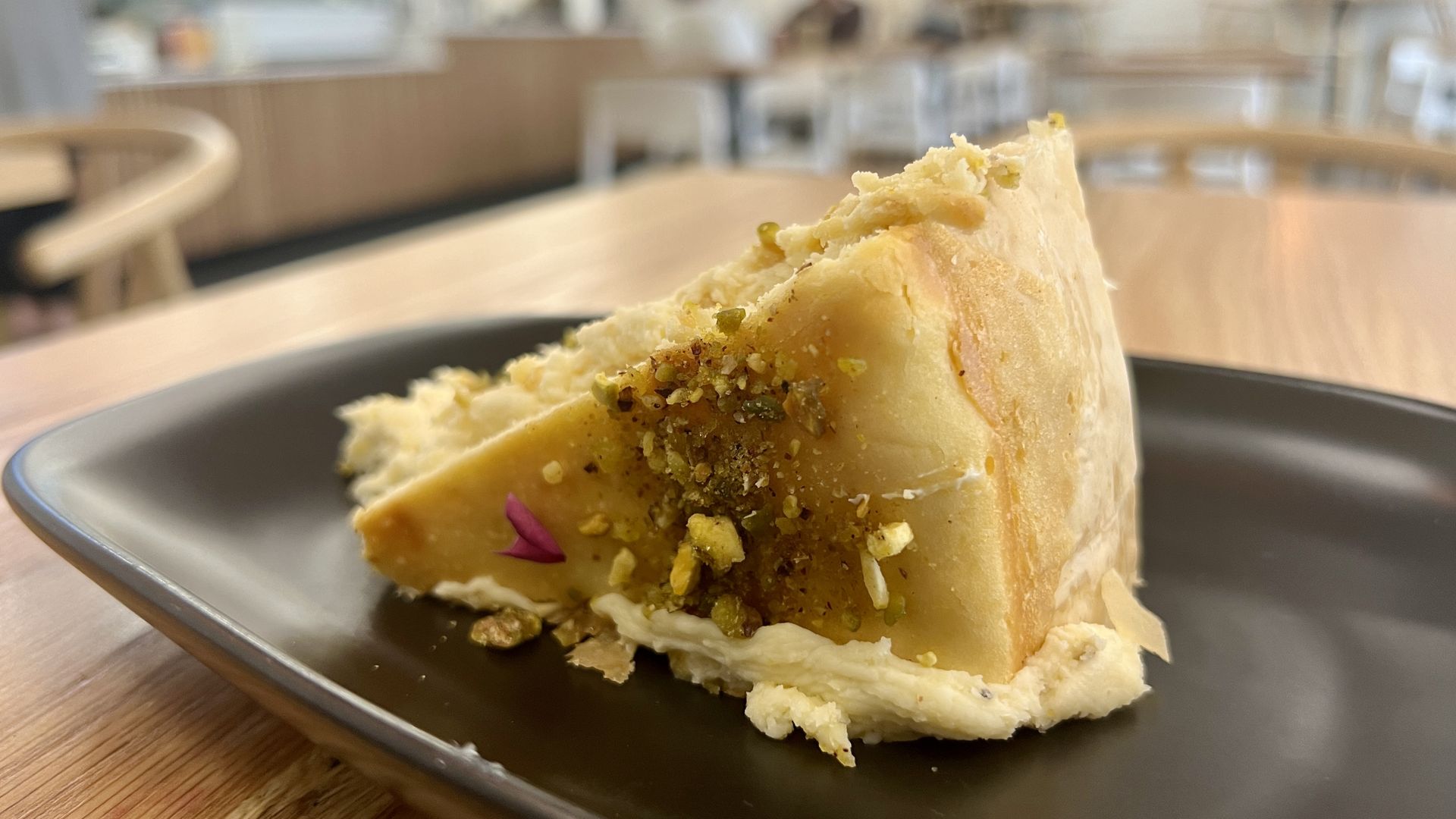 A slice of cheesecake topped with pistachios