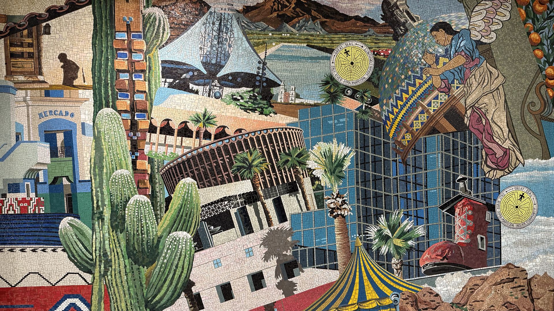 Colorful mosaic featuring cacti, palm trees, modern buildings, a rodeo arena, a red boot-shaped building, an angel figure, and circular seals labeled "Salt River Pima-Maricopa Indian Community."