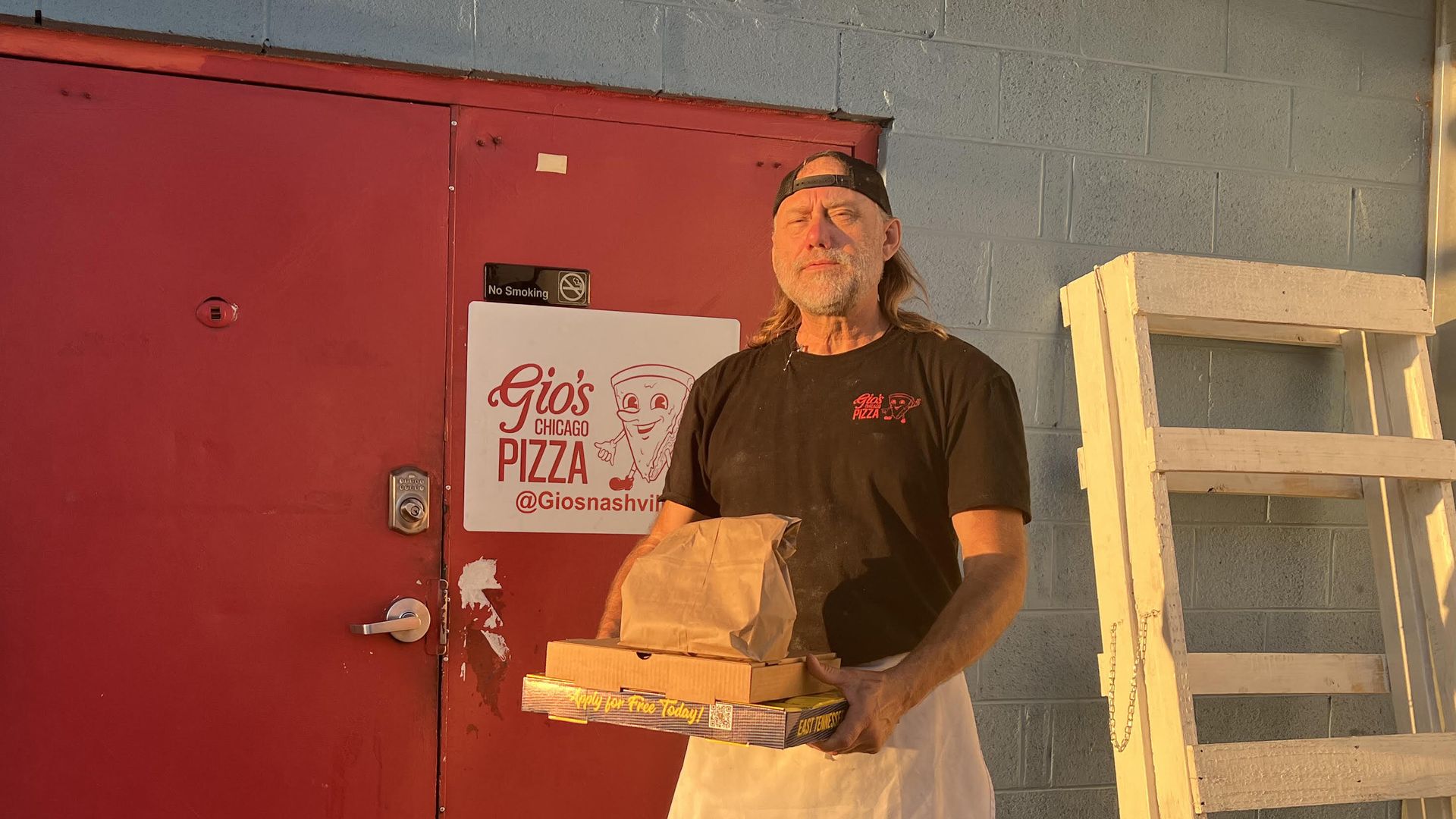 A man standing outside of a Nashville pizza place.