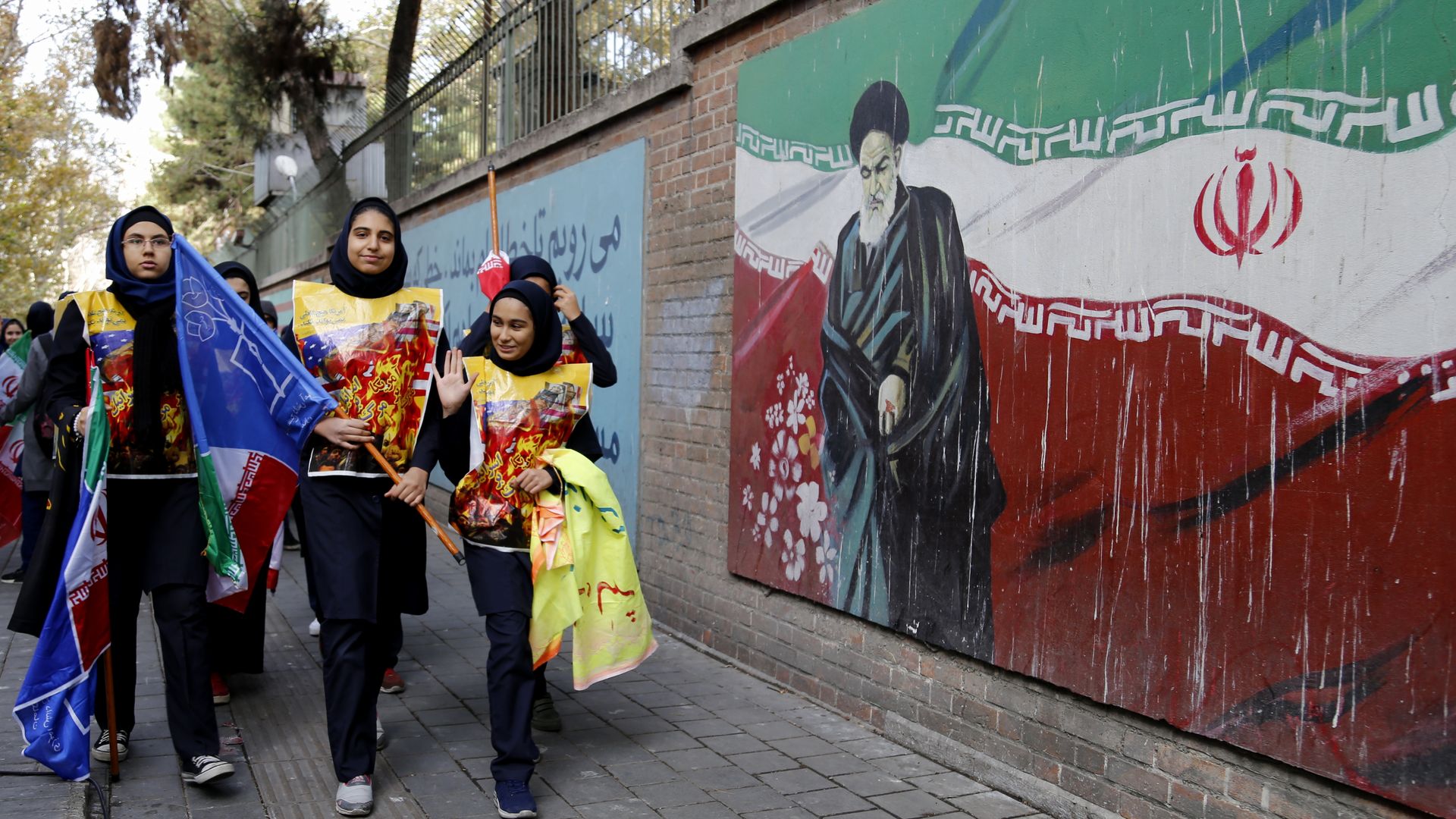 Students pass a pro-Iranian mural. 