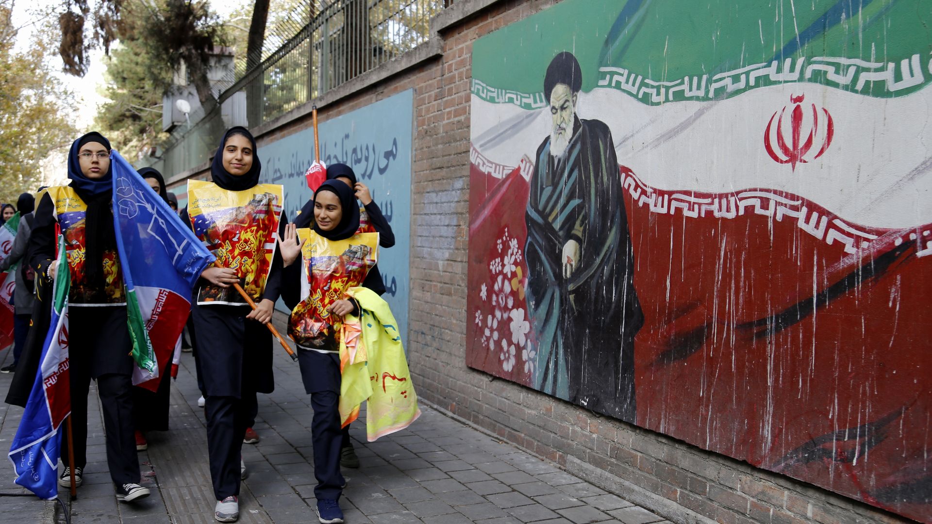 Students pass a pro-Iranian mural.