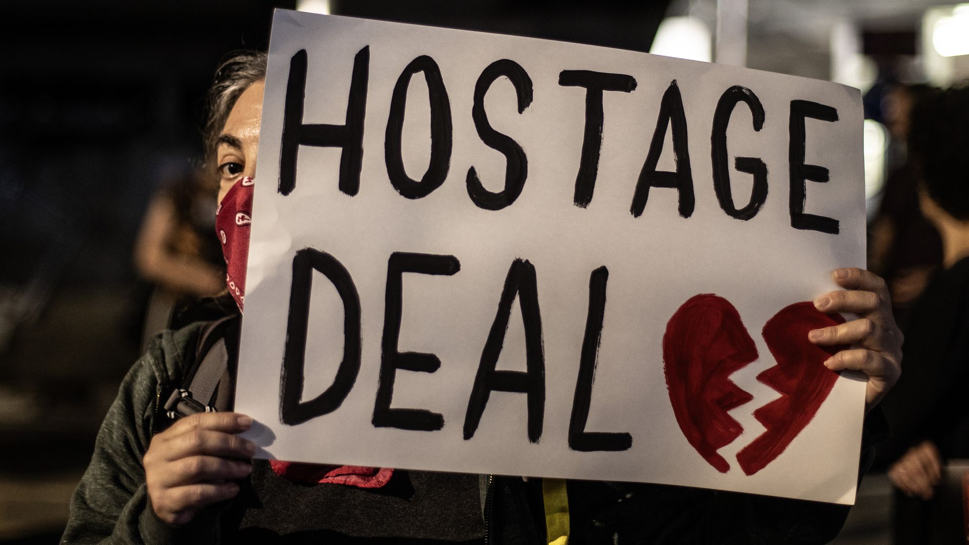 A woman holds a sign saying "Hostage Deal" at a demonstration in Tel Aviv, Israel.