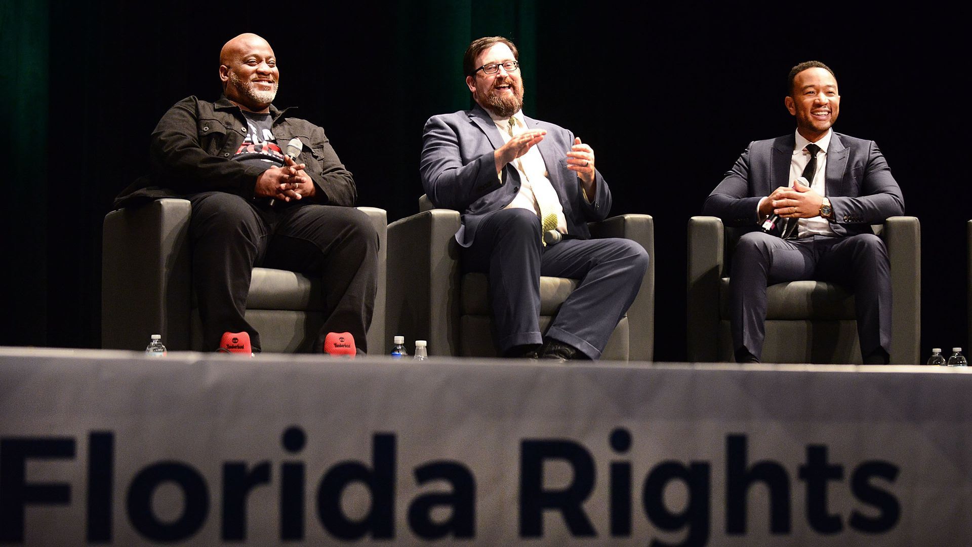 Desmond Meade (left), Neil Volz (center) of the Florida Rights Restoration Coalition and singer John Legend speak on a panel.
