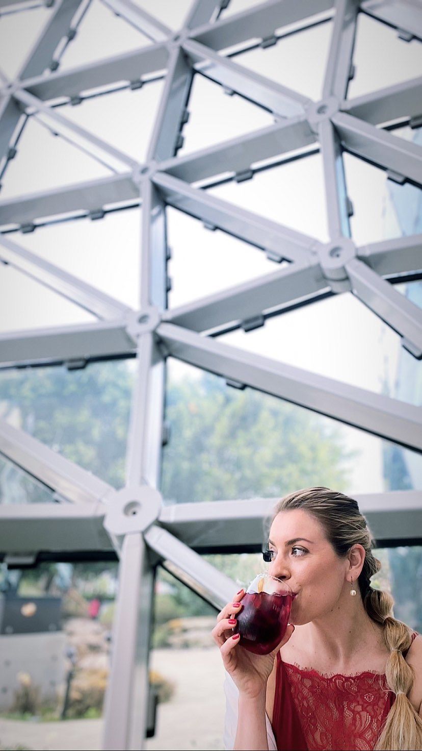 a woman sips wine at the Dali museum