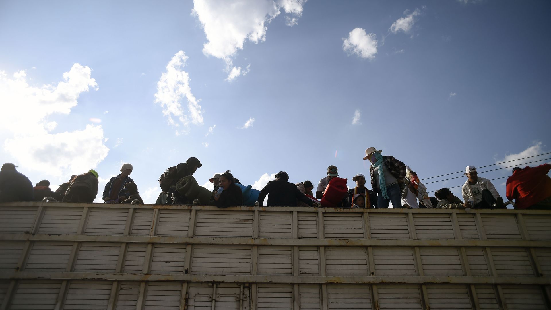 Migrants sit on a truck. 