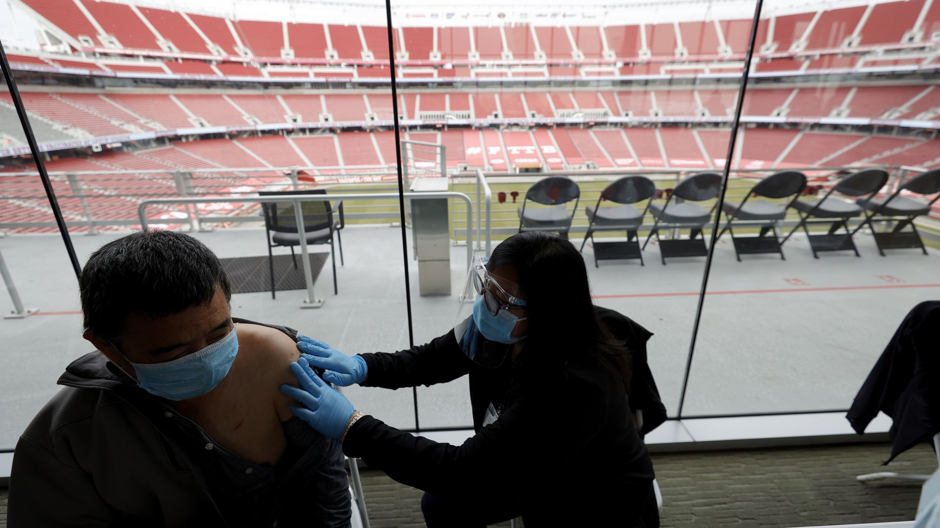 Xiangheng Liu, 69, (L) of San Jose prepares to receive a COVID-19 vaccination in Santa Clara, California.