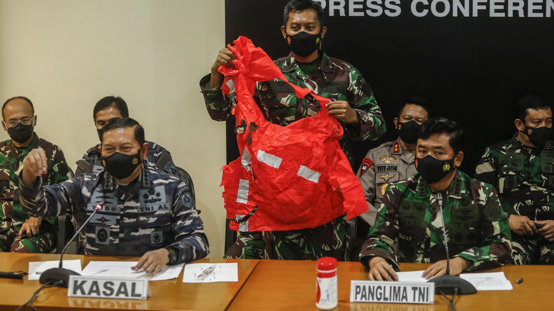 An Indonesian military officer shows a crew escape suit from sunken Indonesian Navy submarine during a press conference at Ngurah Rai Military Air Base in Kuta, Bali, Indonesia on Sunday. 