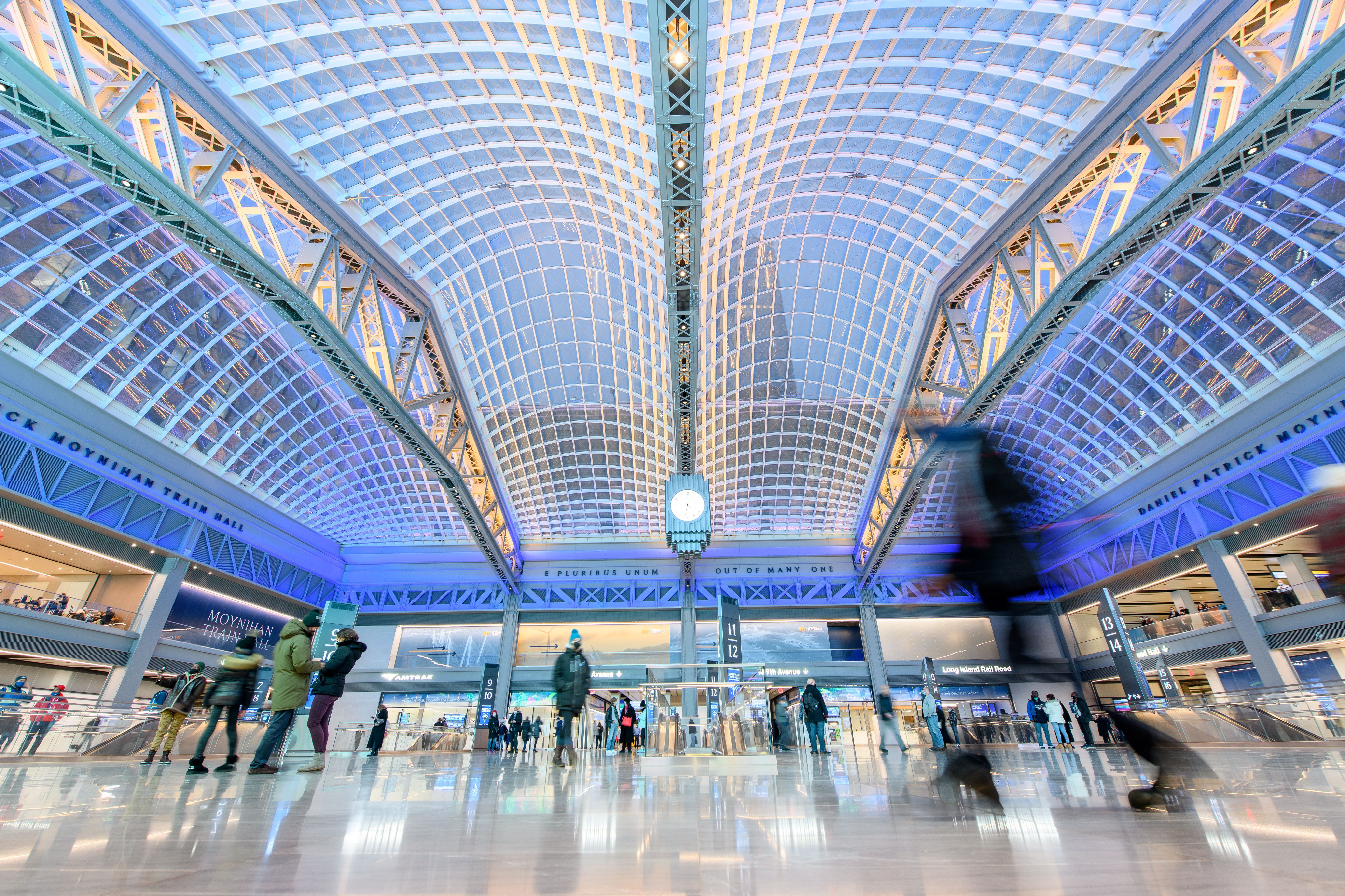 Picture of the inside of the station showing the glass ceiling and people walking around