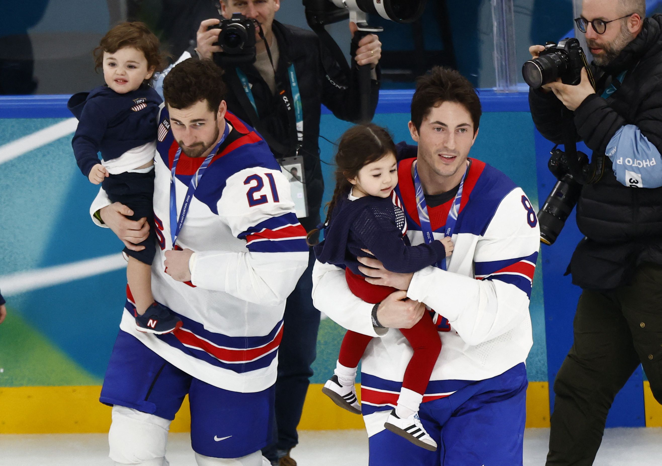 Dylan Larkin and Zach Werenski carry Noa and Johnny Gadreau Jr. onto the ice after winning the gold medal yesterday. 