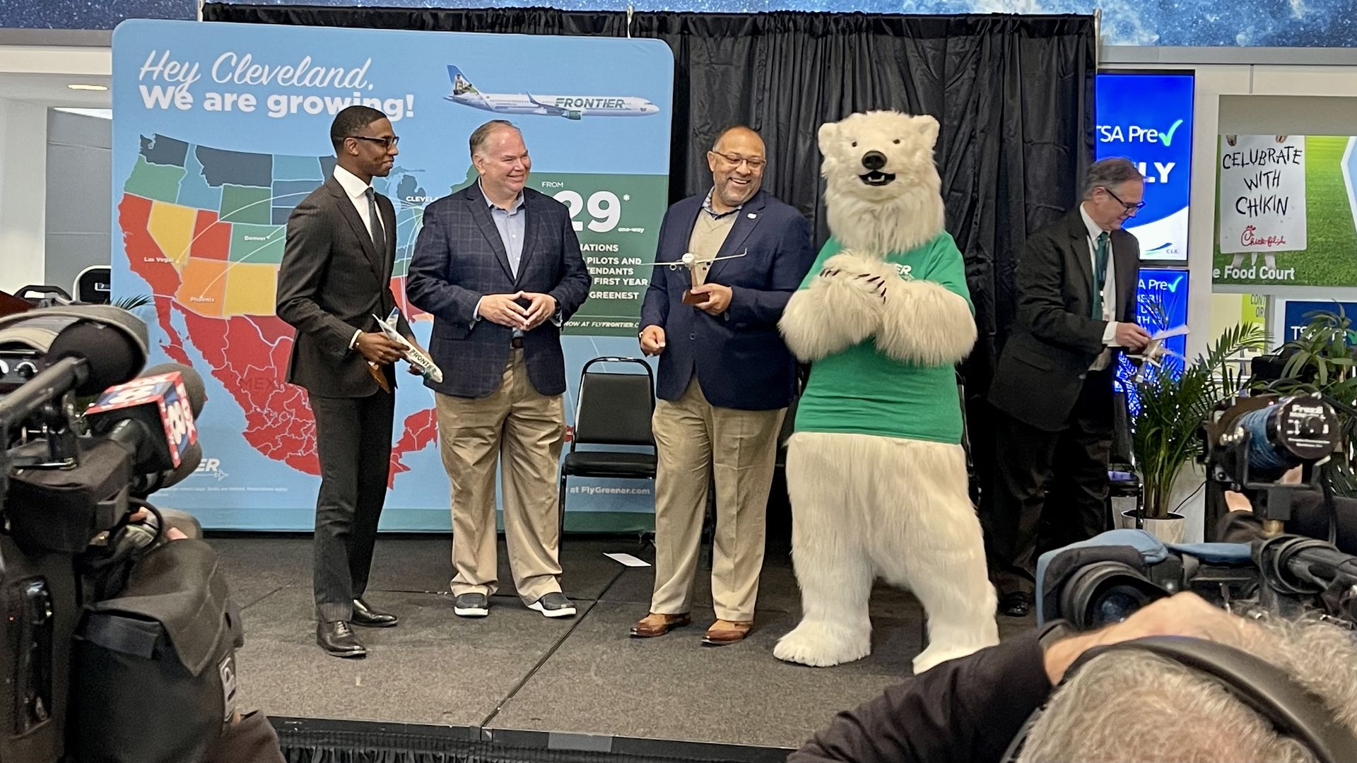 Cleveland officials with Polar Bear mascot for Frontier Airlines standing at press event